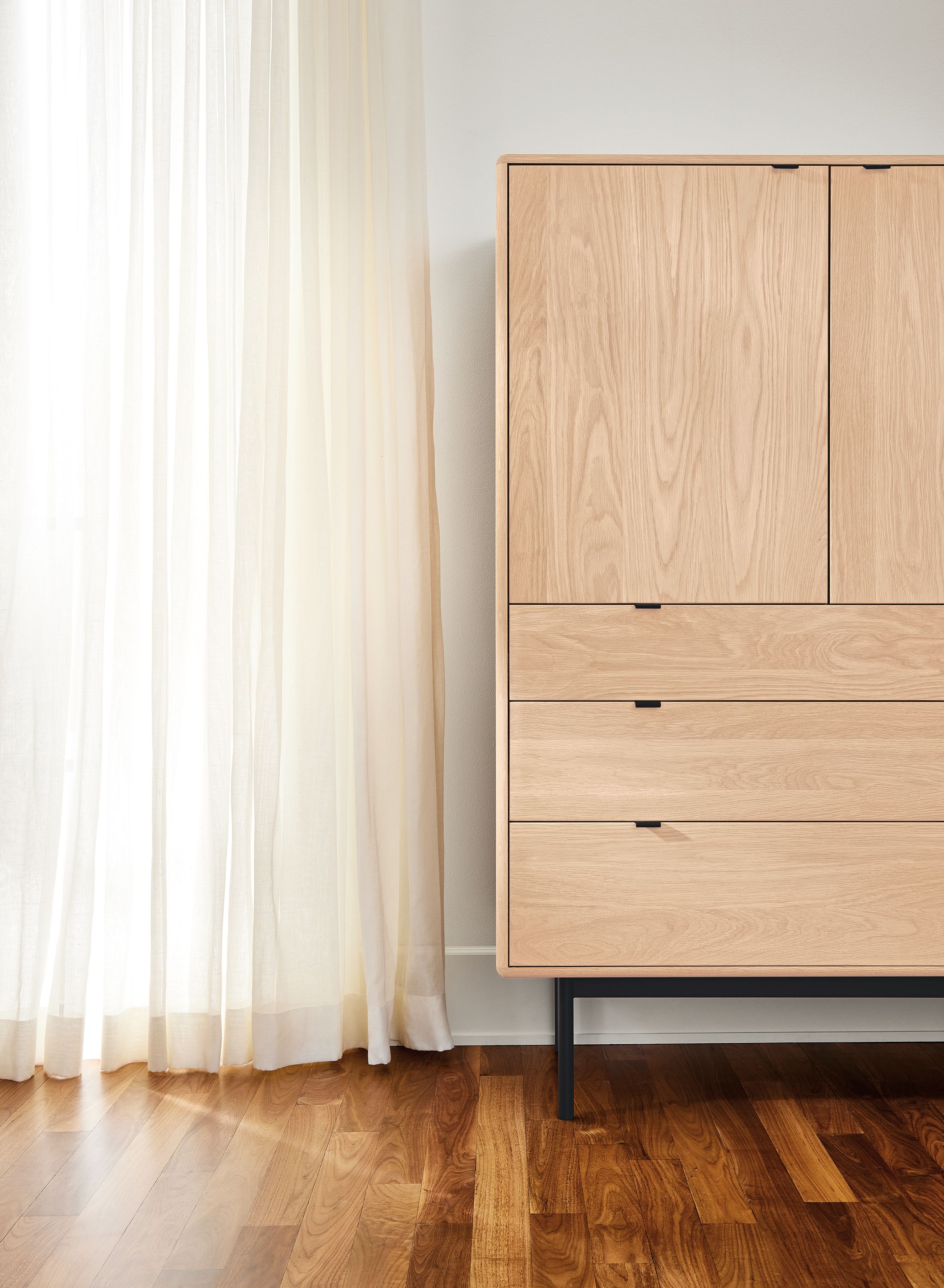 Room with Hensley armoire in salt on  red oak and graphite with black hardware.