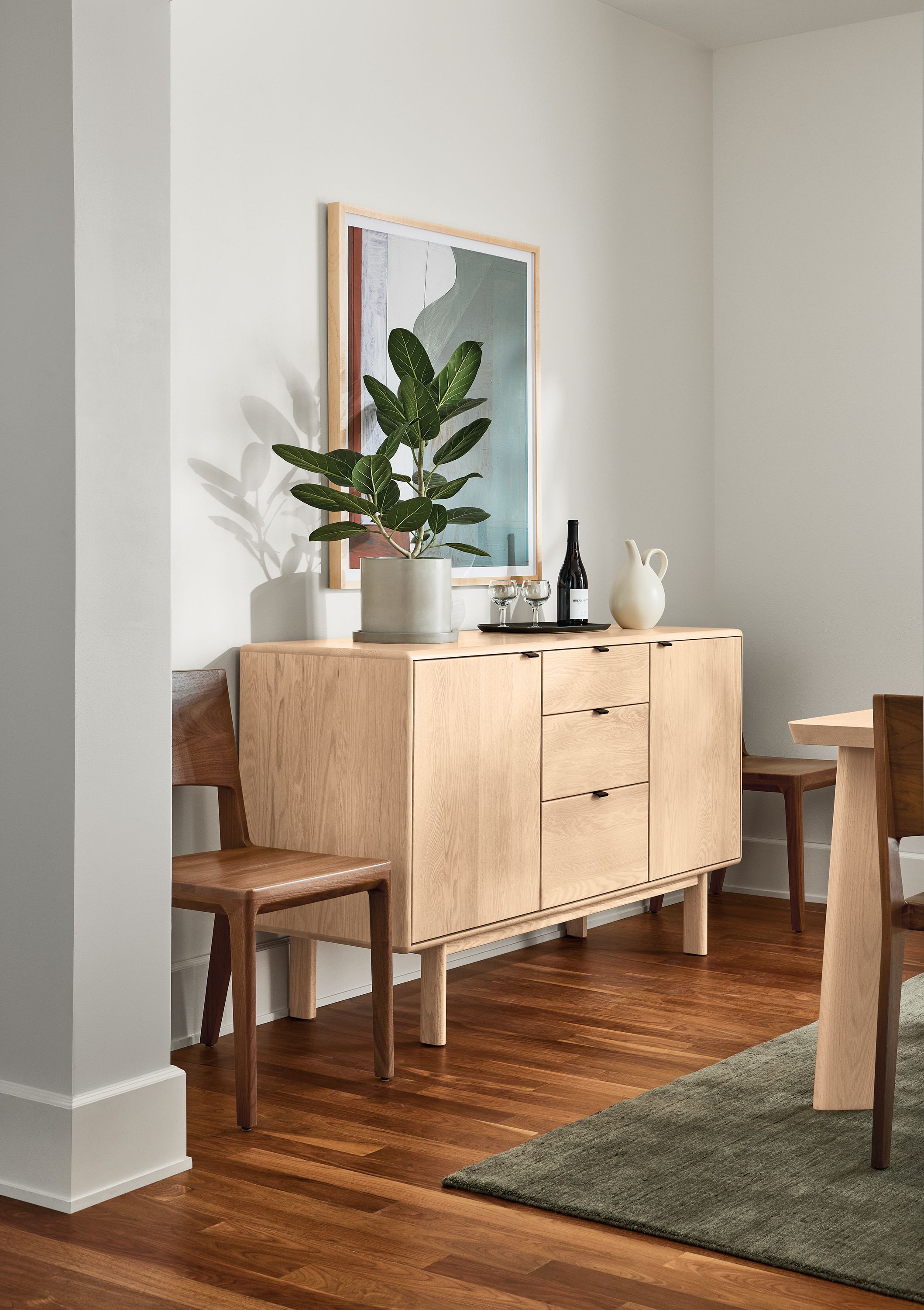 Dining room with Hensley 60-wide storage cabinet in salt on red oak and Nomad rug in olive.