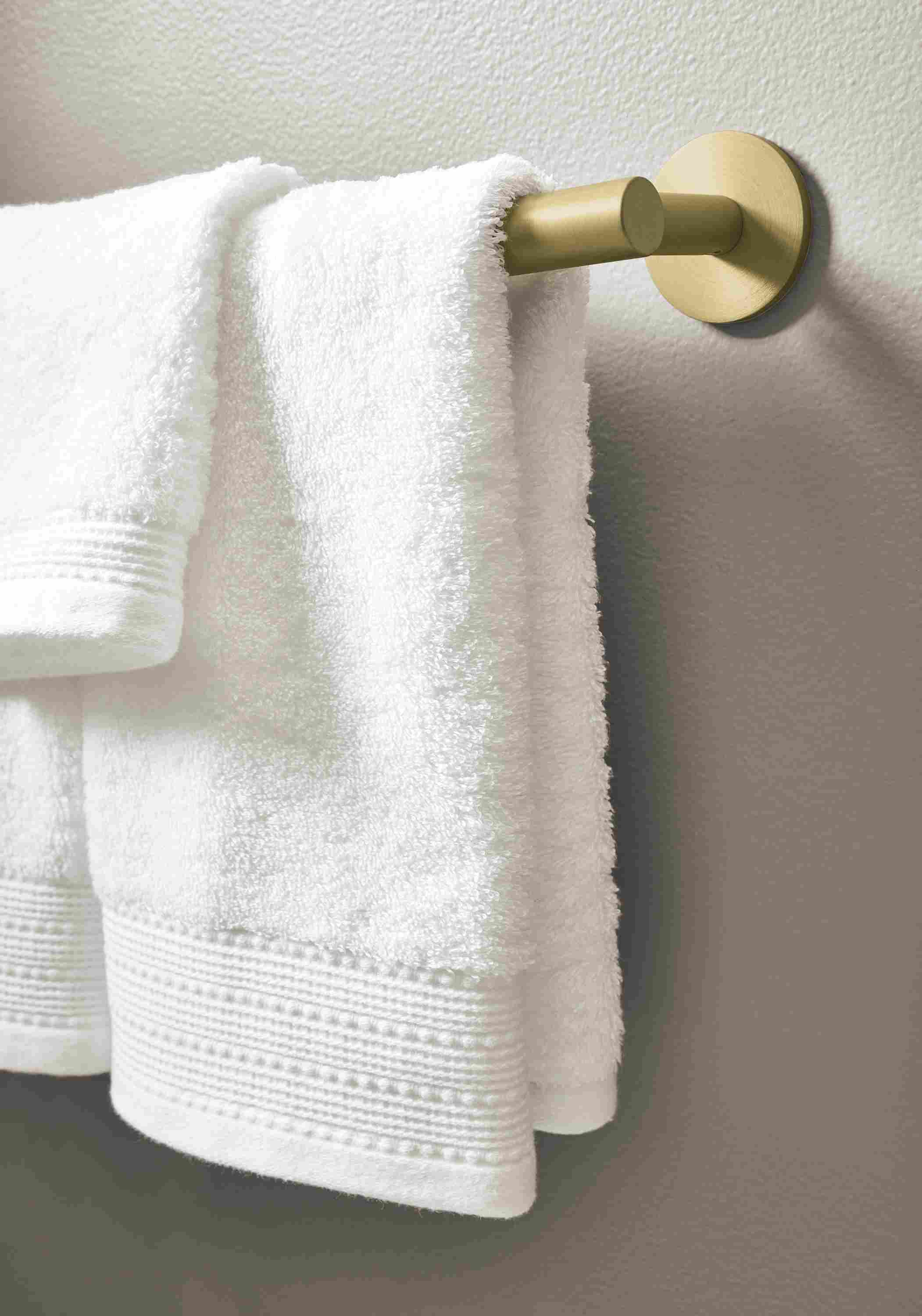 Detail of Hoff 18-wide towel rack in brushed gold powdercoat and Fendwick towels and washcloths in white.