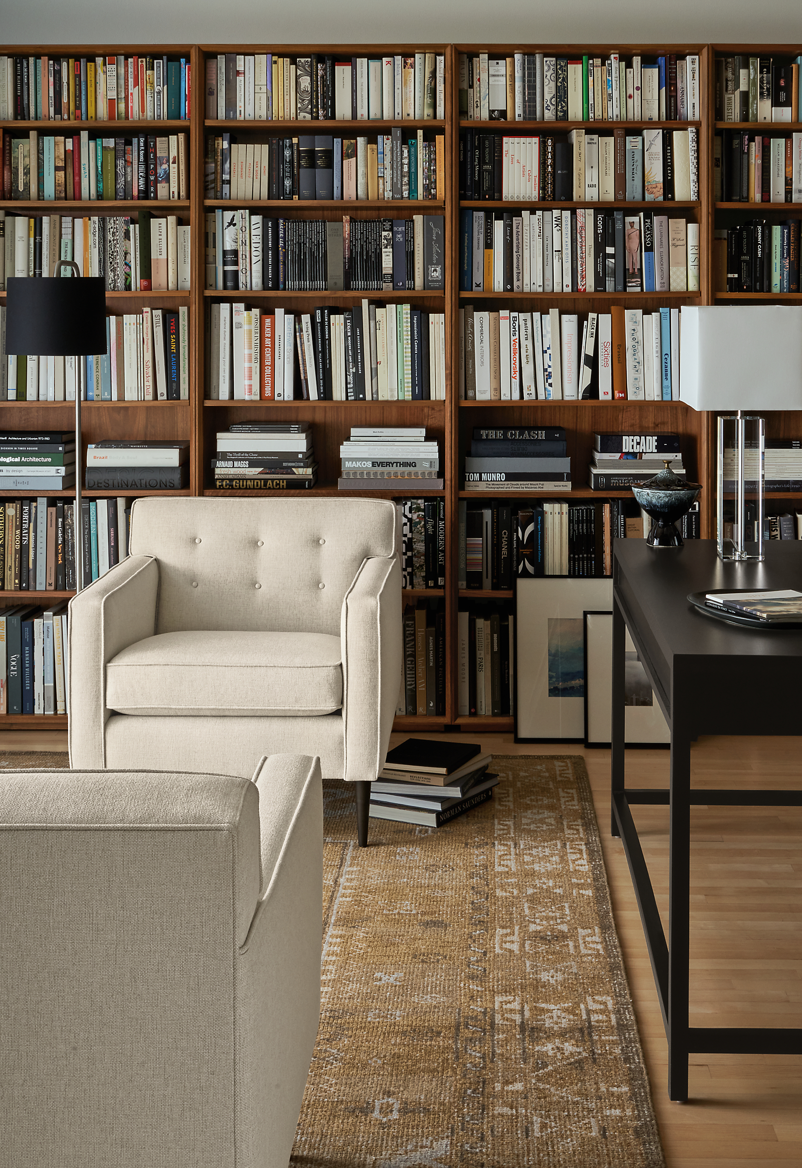 Living room library with Holmes 30 inch chair in Sumner Ivory with Rollins bookcases in walnut and Darrah rug in camel.