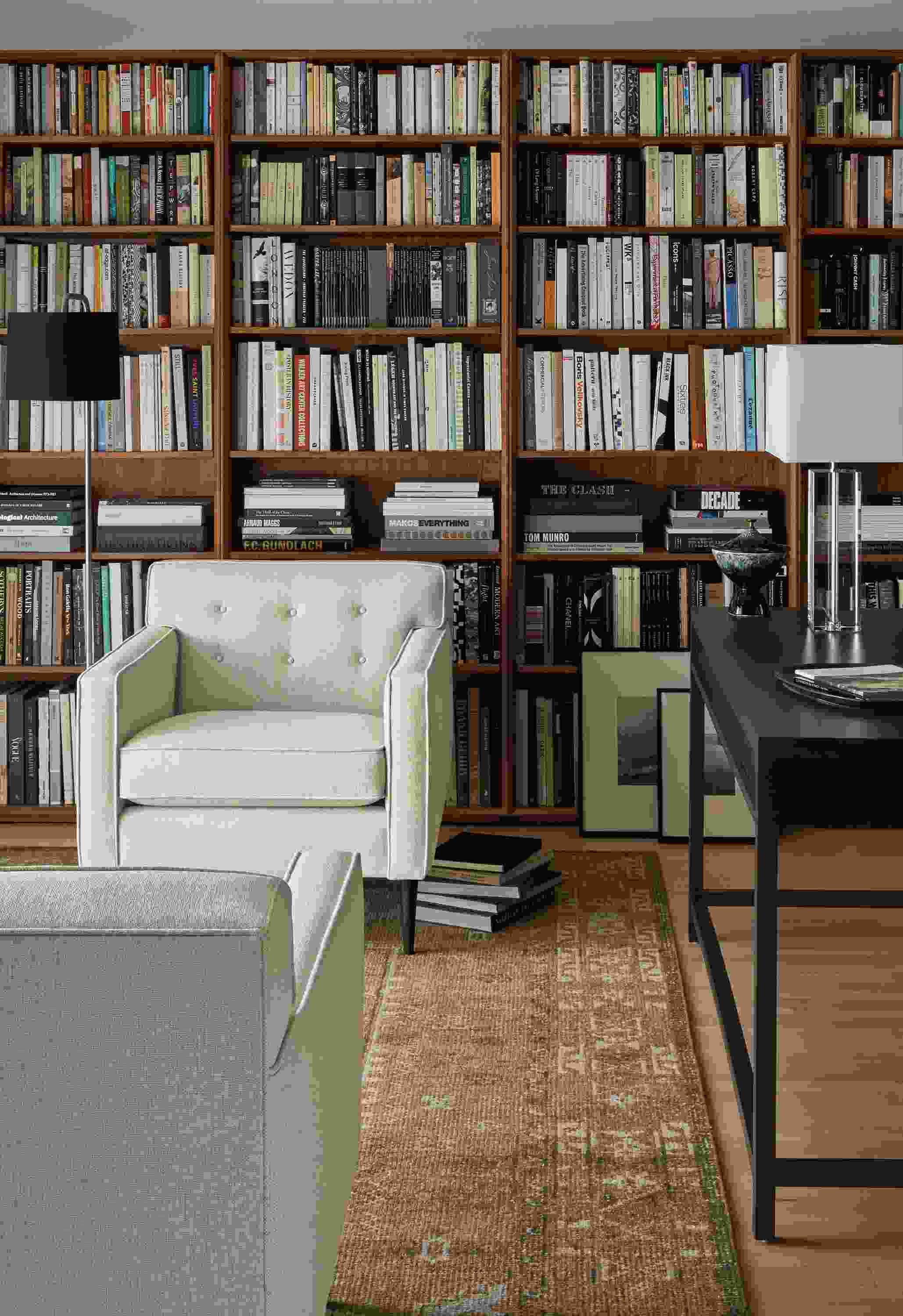 Living room library with 2 Holmes 30-inch chairs in Sumner Ivory, Rollins bookcases in walnut and Darrah rug in camel.