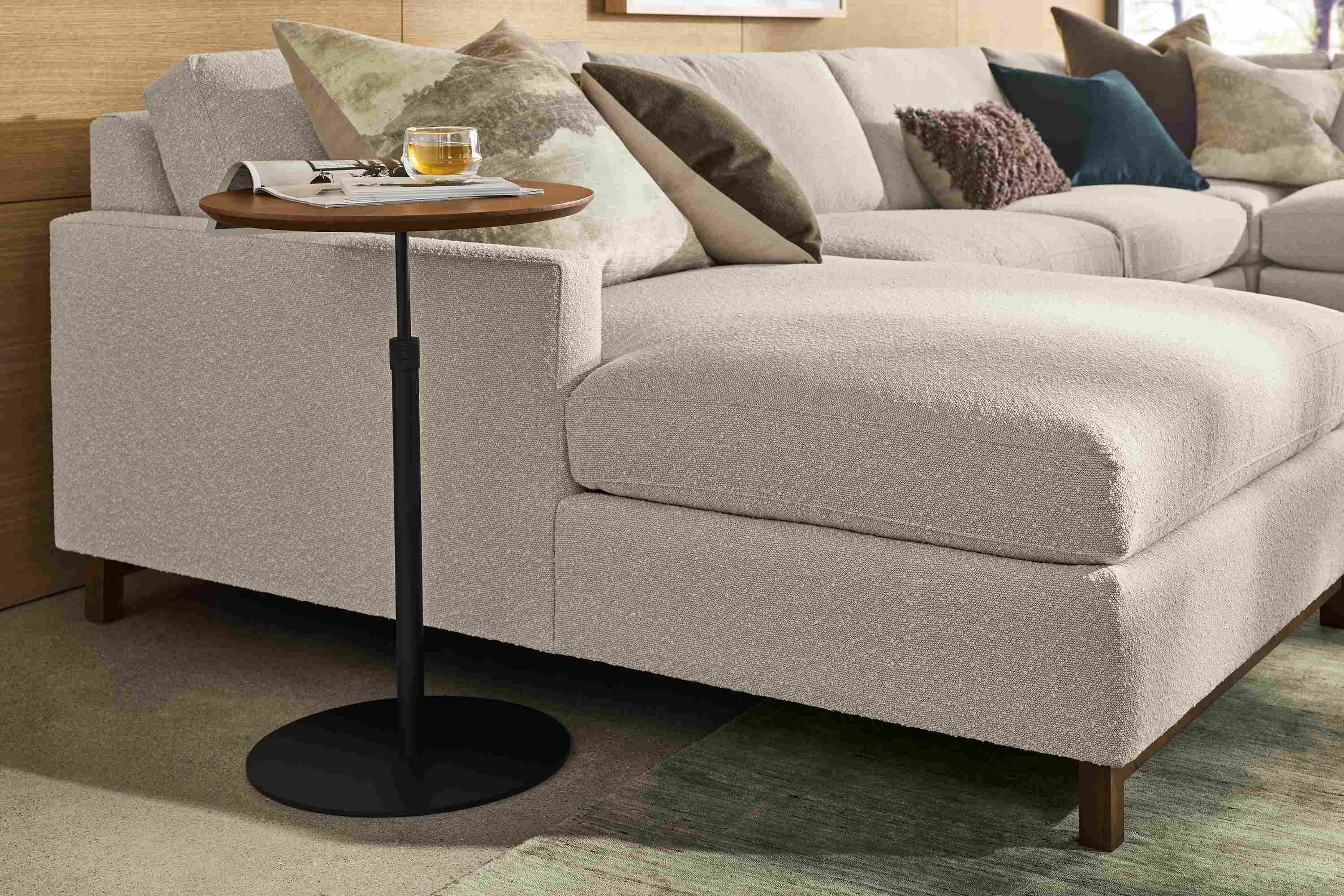 Living room with Hopper 18-diameter C-table in graphite and walnut shown in up position and Stevens sofa in Declan Natural.