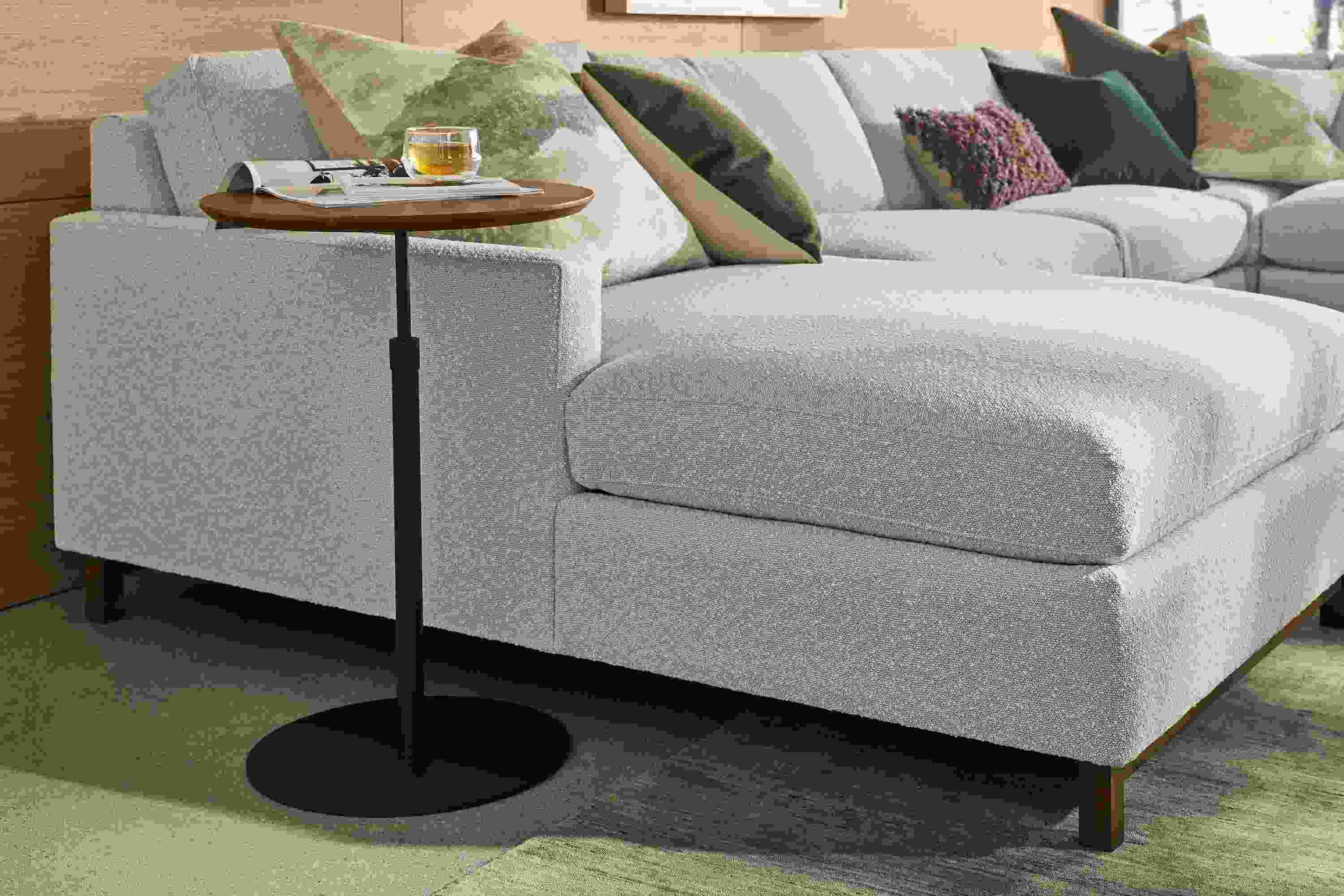 Living room with Hopper 18-diameter C-table in graphite and walnut shown in up position and Stevens sofa in Declan Natural.