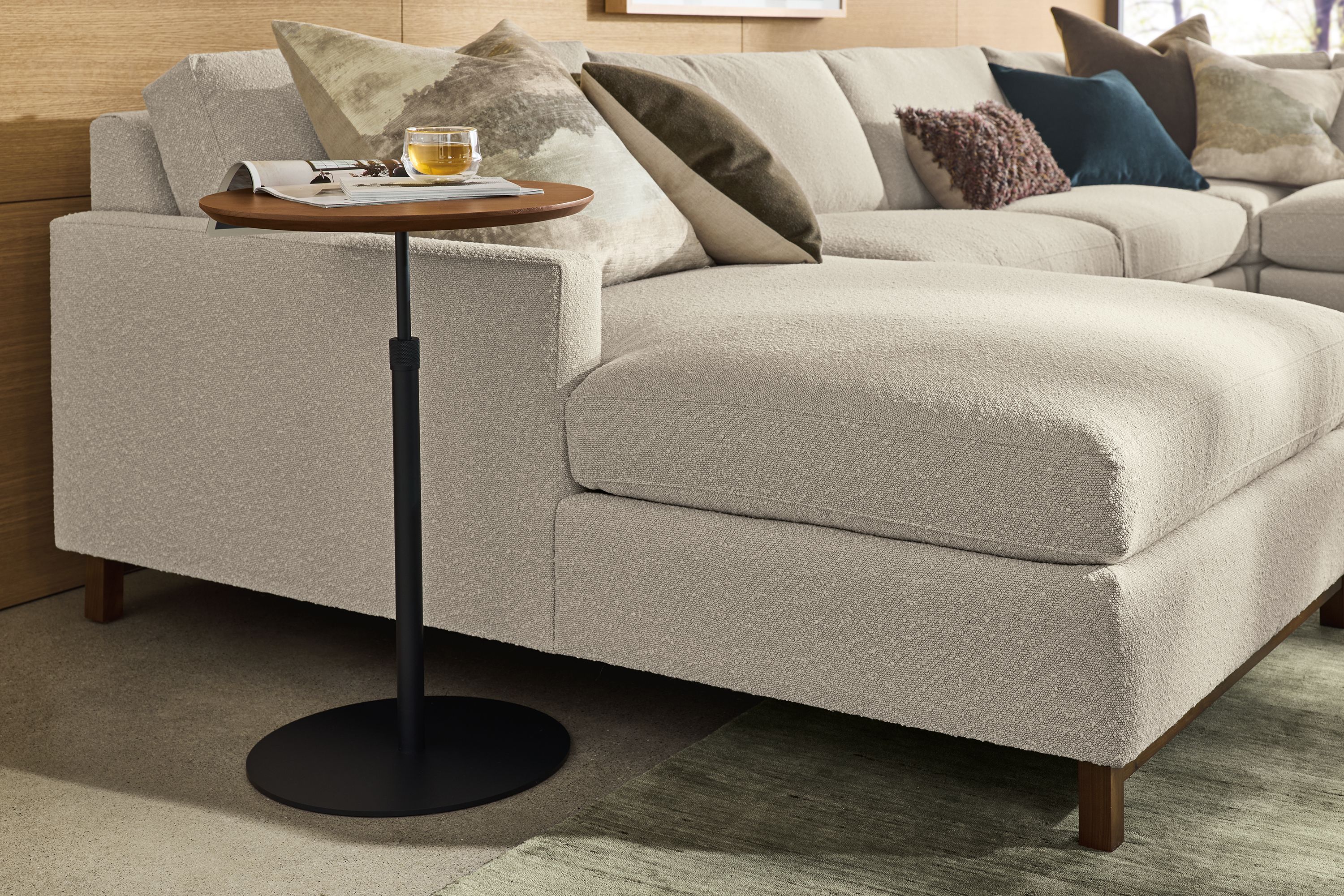 Living room with Hopper 18-diameter C-table in graphite and walnut shown in up position and Stevens sofa in Declan Natural.