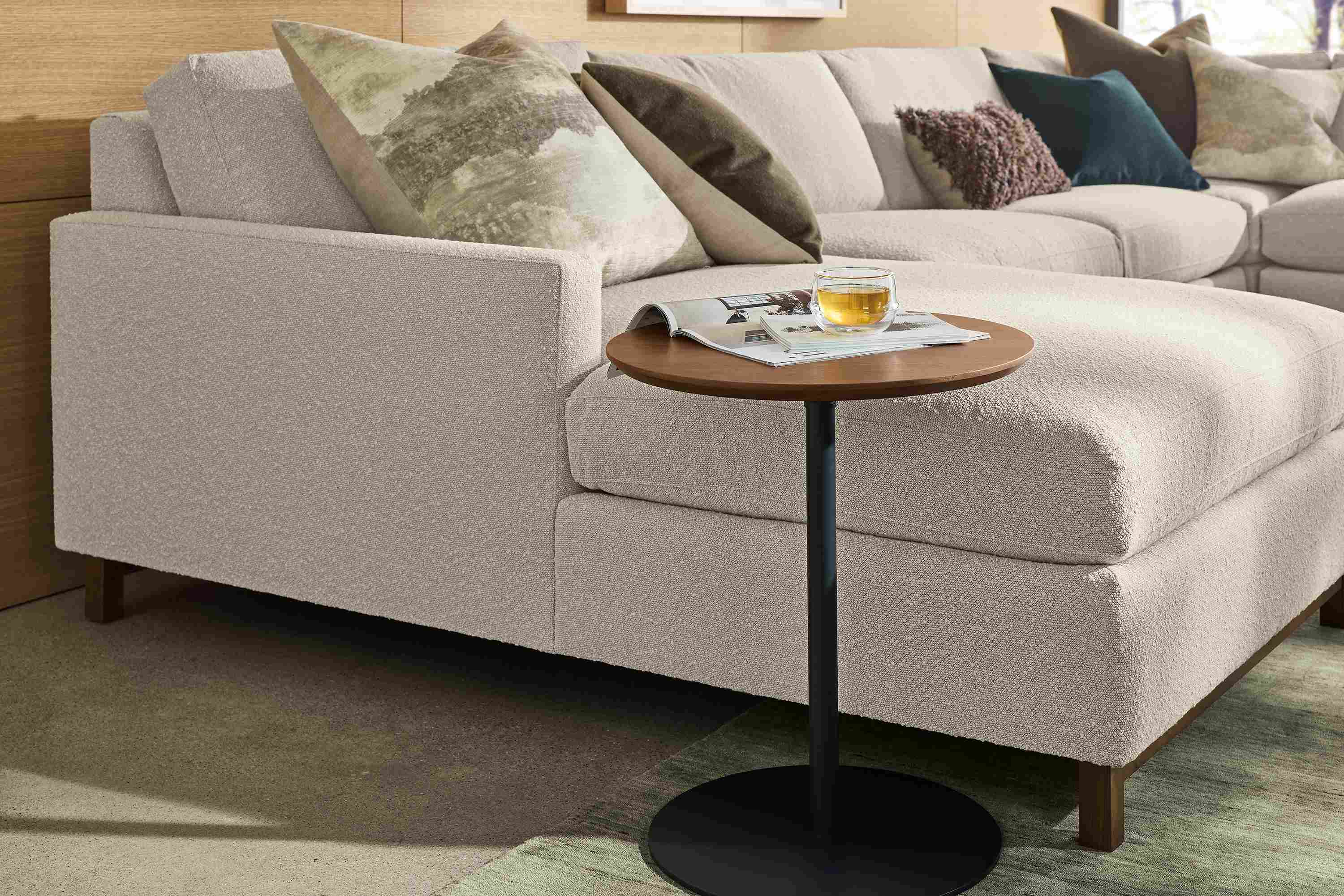 Living room with Hopper 18-diameter C-table in graphite and walnut and Stevens sectional sofa in Declan Natural.