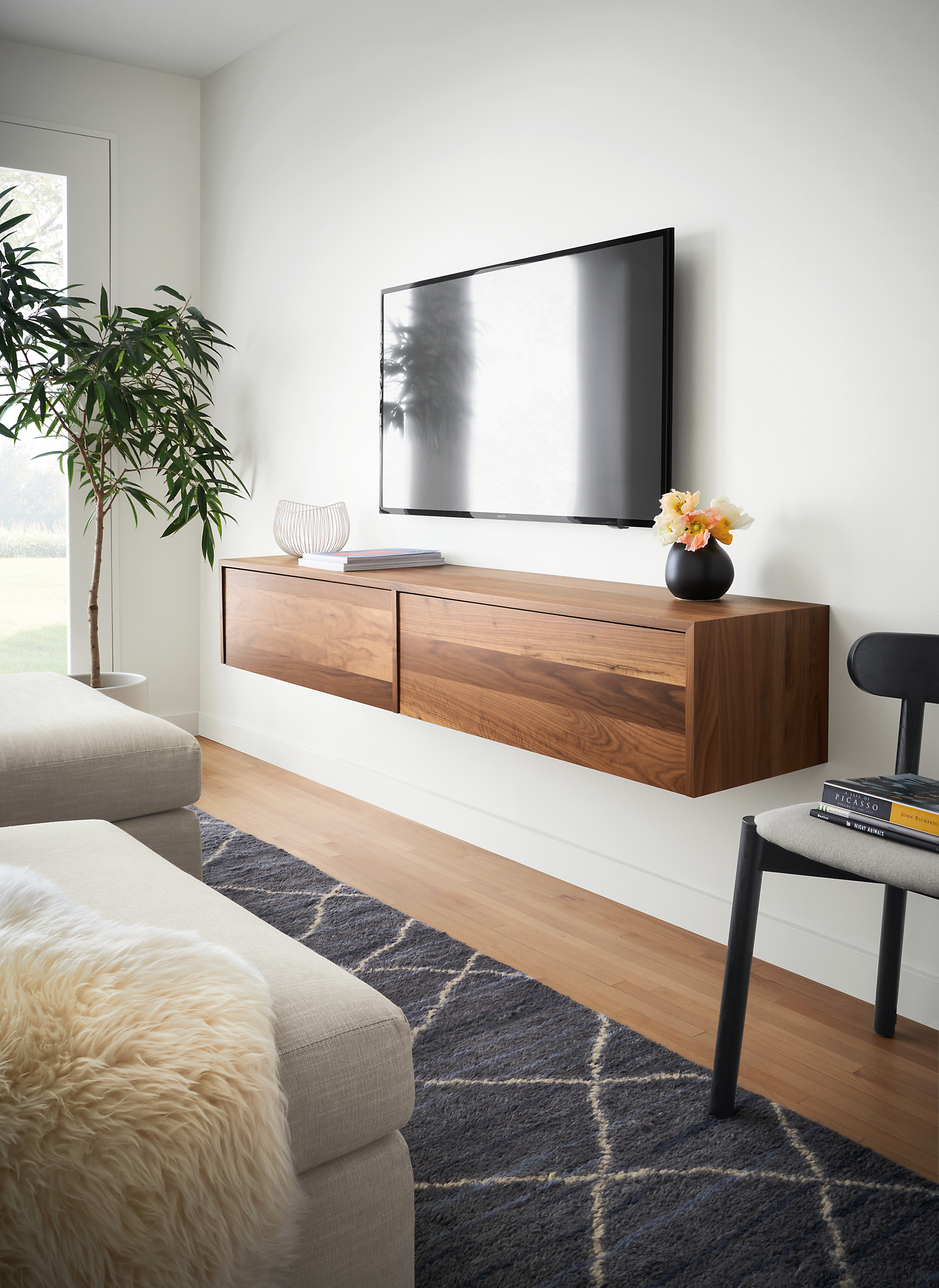 living room with hover wall-mounted meda cabinet in walnut with tv wall-mounted above it.