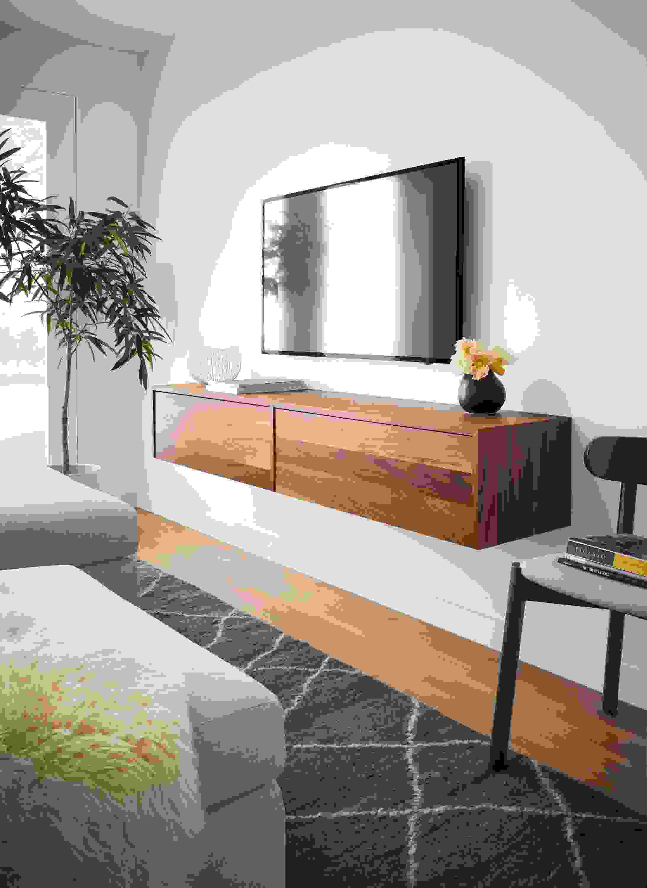 living room with hover wall-mounted meda cabinet in walnut with tv wall-mounted above it.
