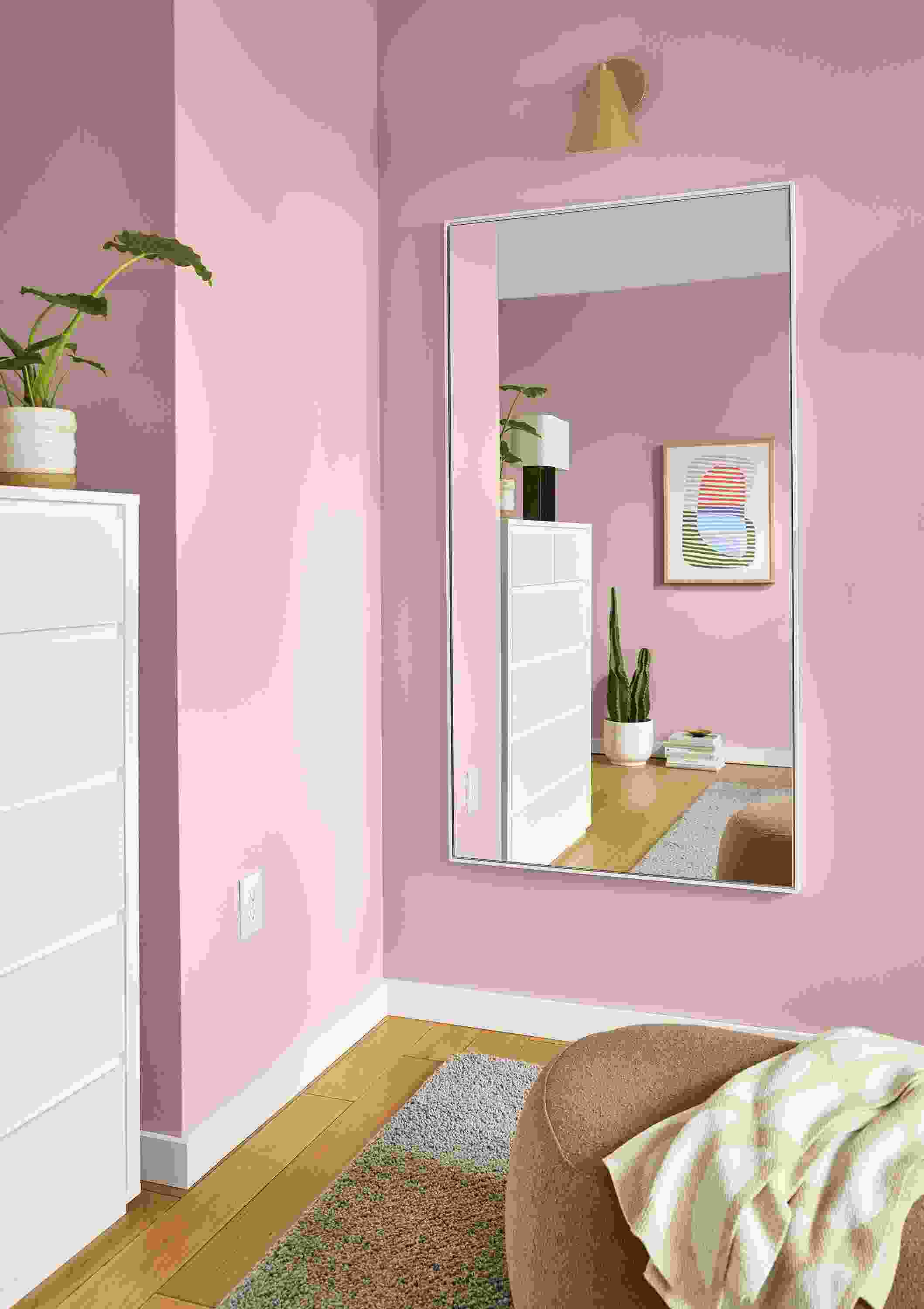 Room with detail of Hudson 64-wide Hudson mirror in white and Gardner indoor wall sconce in gold.