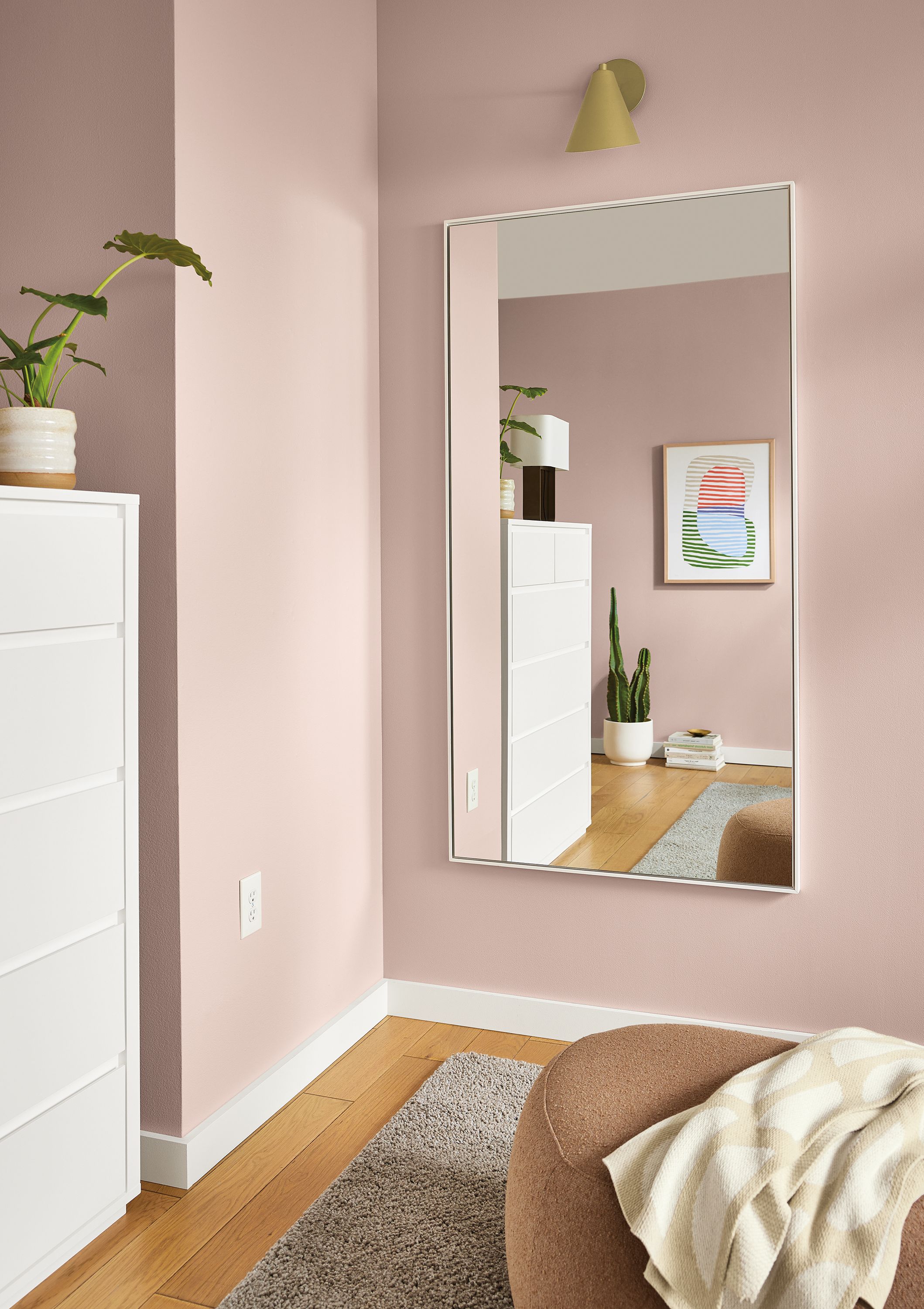 Room with detail of Hudson 64-wide Hudson mirror in white and Gardner indoor wall sconce in gold.