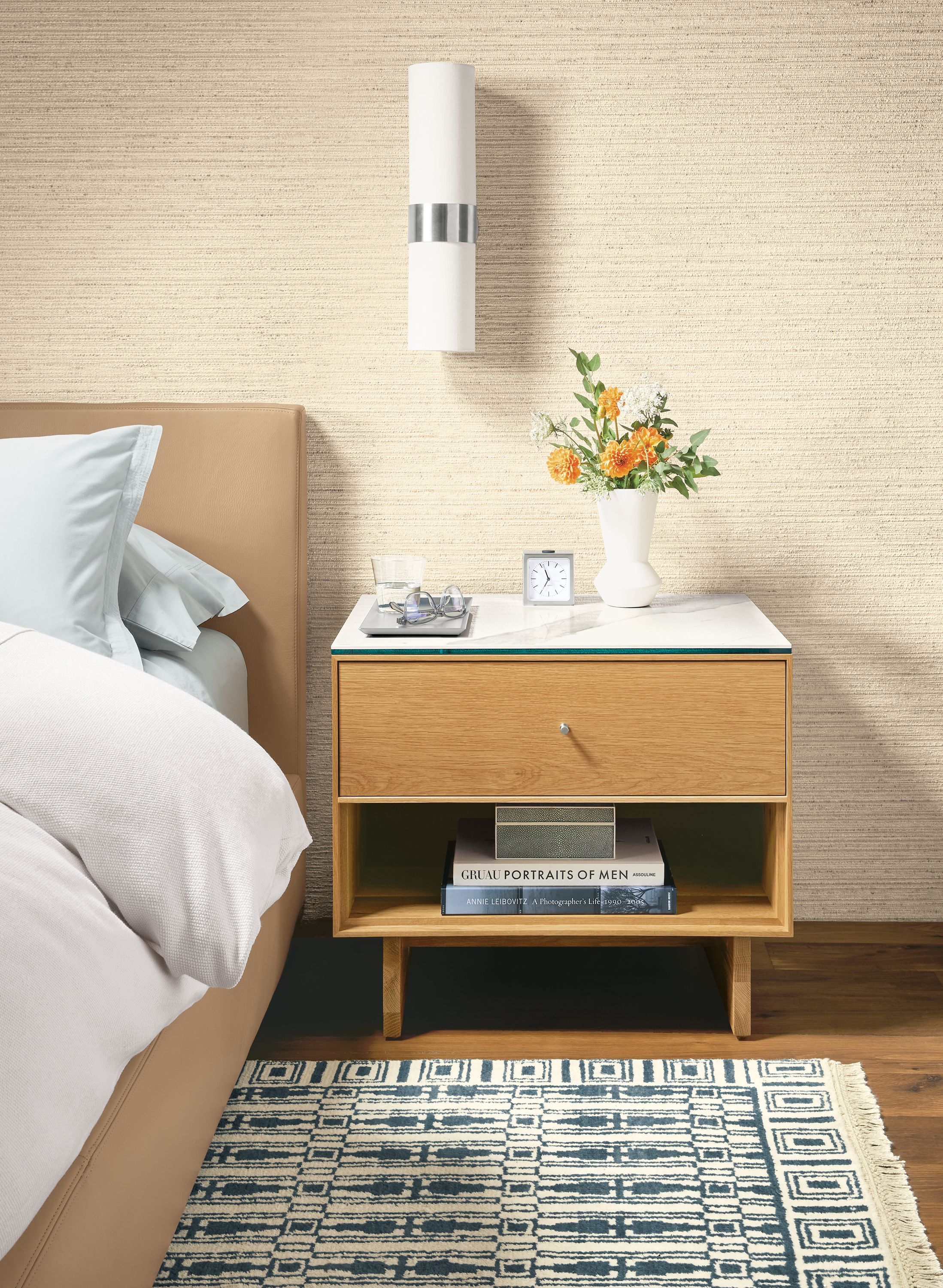 Detail of Hudson nightstand with wood base in white oak and ceramic top beside Wyatt leather bed.