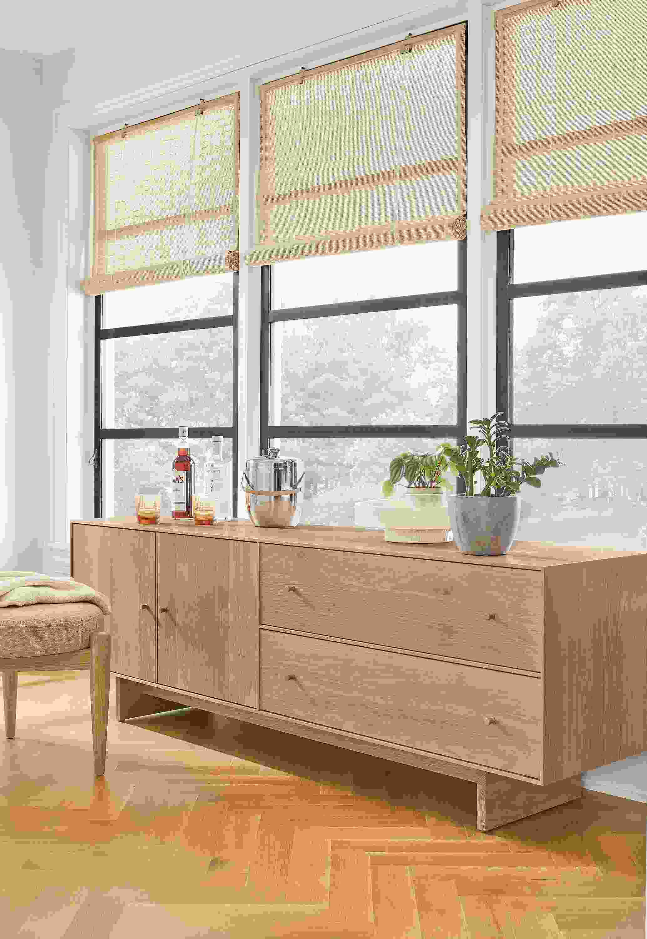 Detail of Hudson media cabinet with wood base in Rye next to Murphy ottoman in Declan Blush.