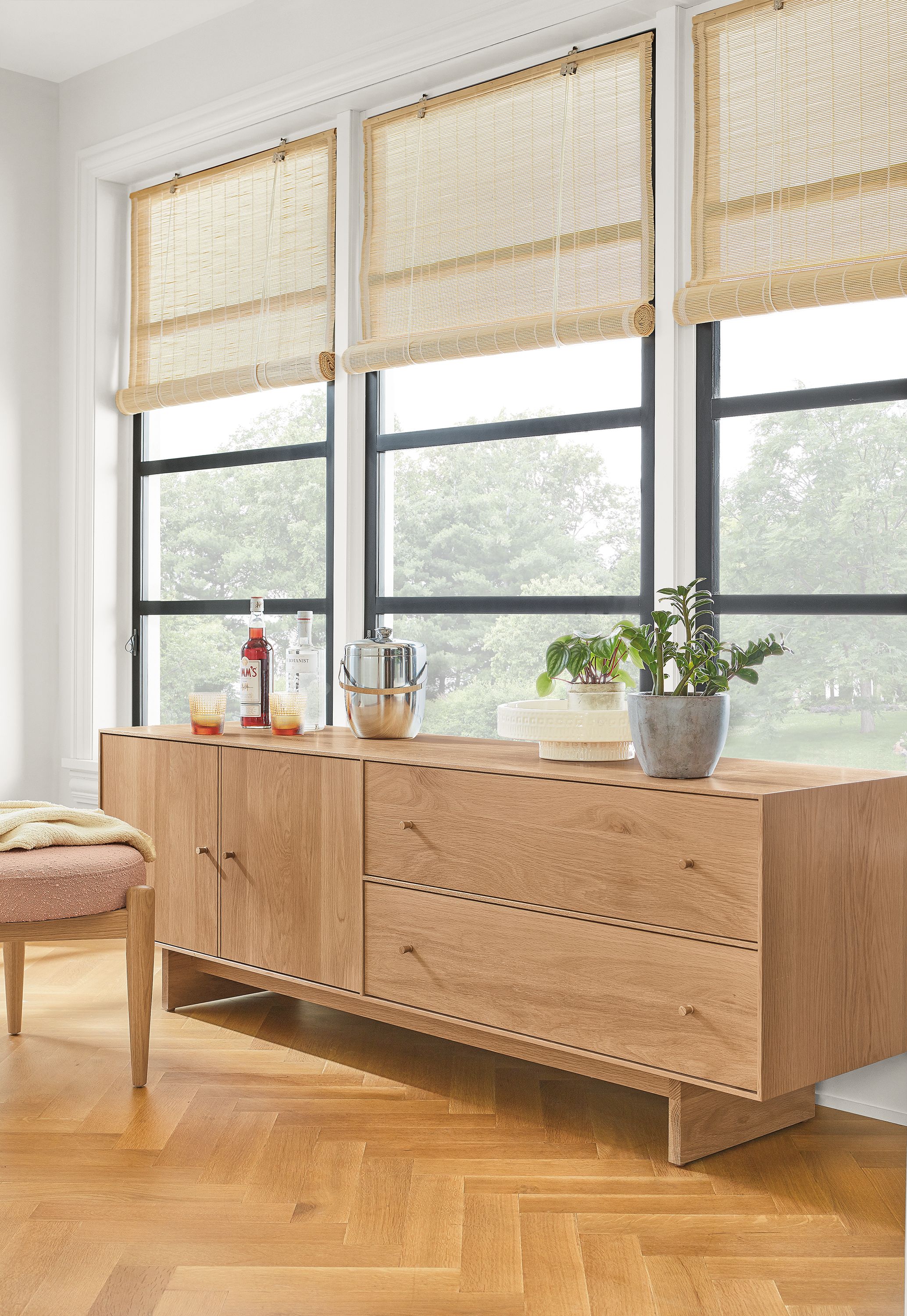 Detail of Hudson media cabinet with wood base in Rye next to Murphy ottoman in Declan Blush.