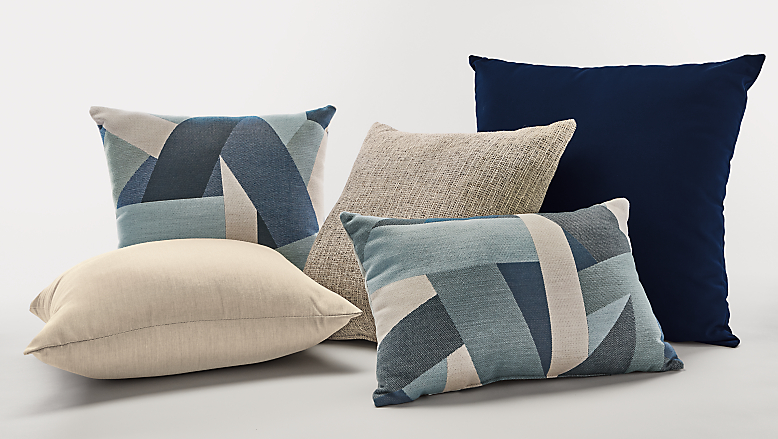 Collection of outdoor pillows in blue and taupe.