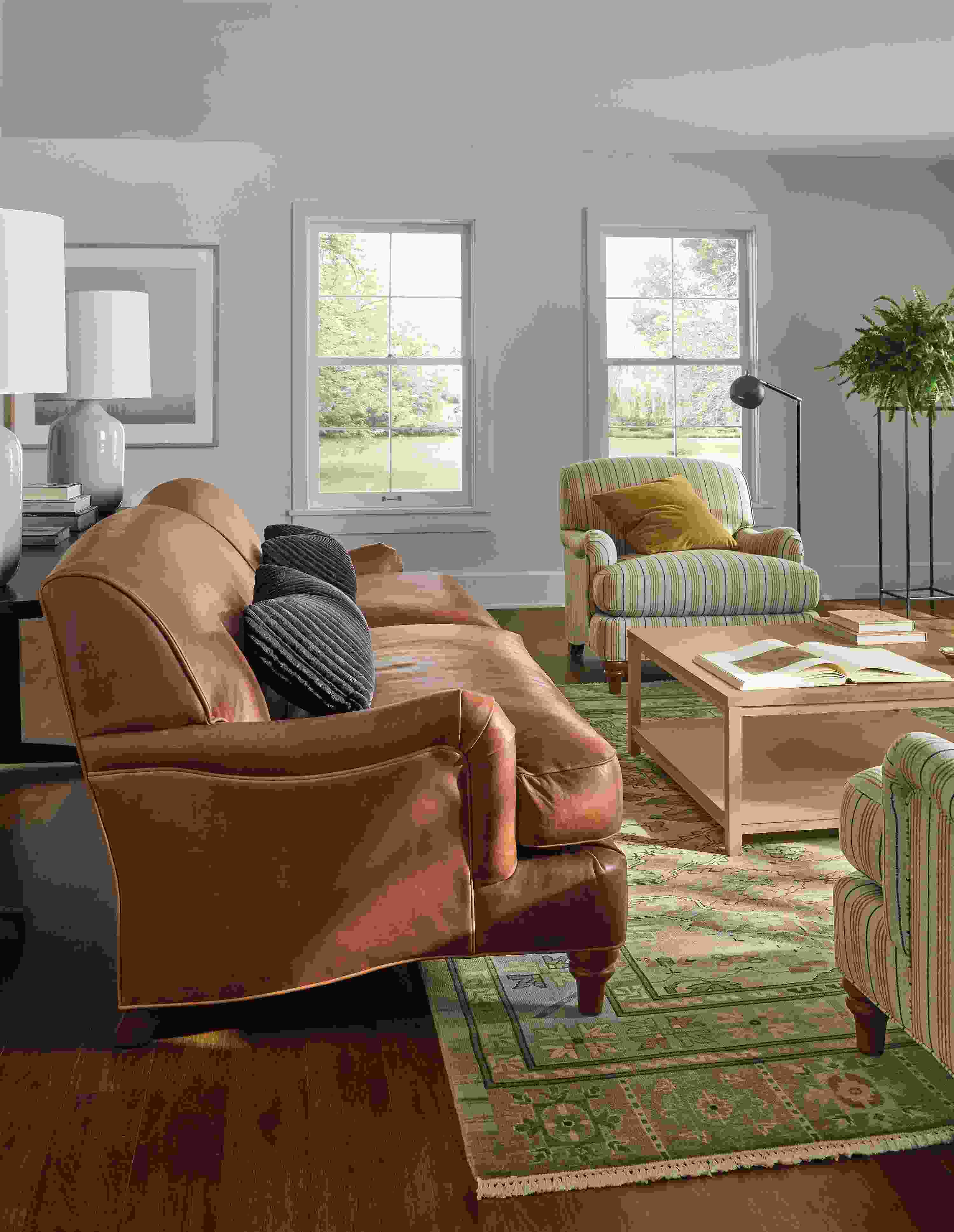 Living room with side view of a Humphrey 92-wide sofa in Sarto Cognac leather and Clark coffee table in Red oak with rye stain.