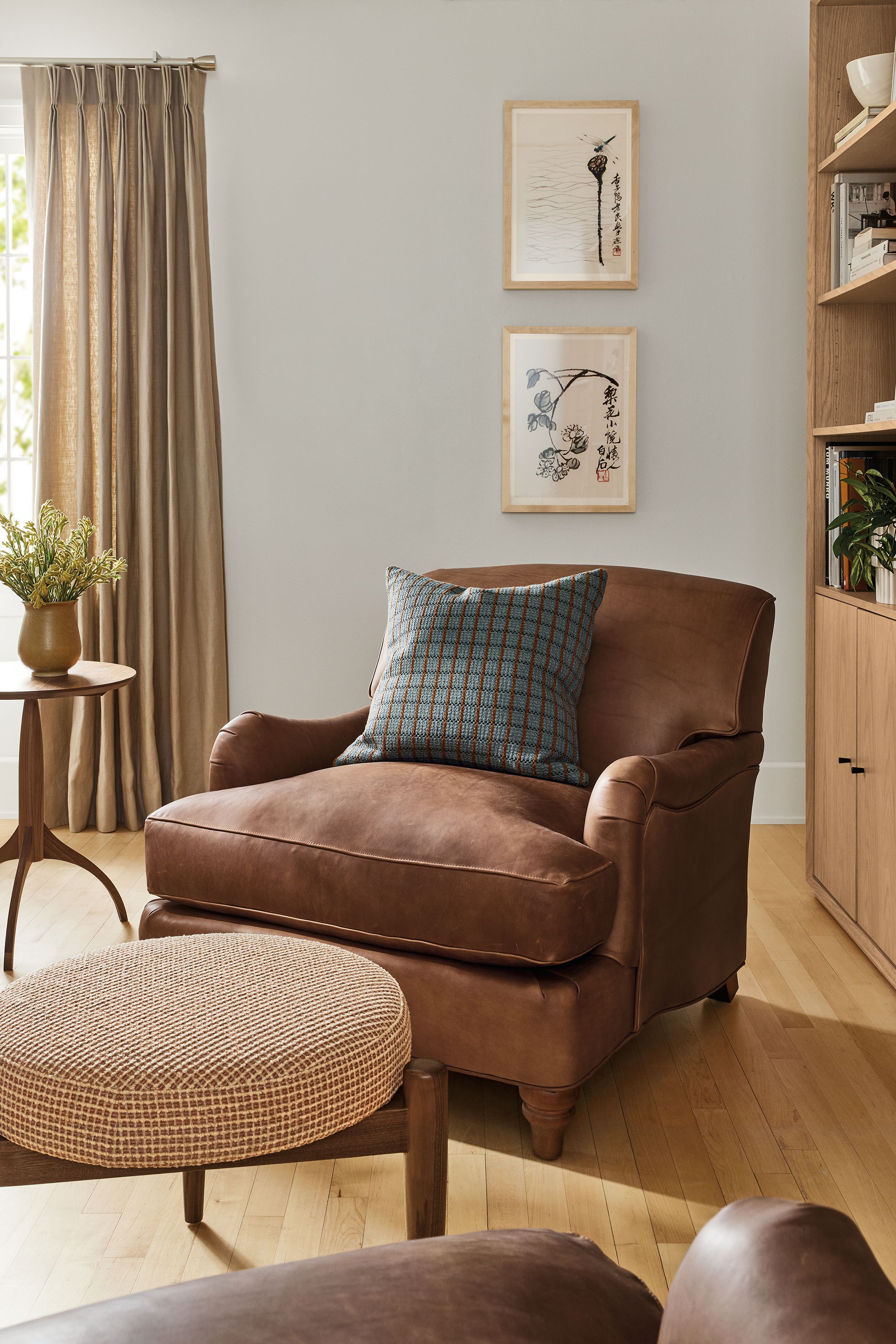 Living room with Humphrey chair in sarto cognac, Murphy round stool in Dorsa Clay and Adams round table in walnut.