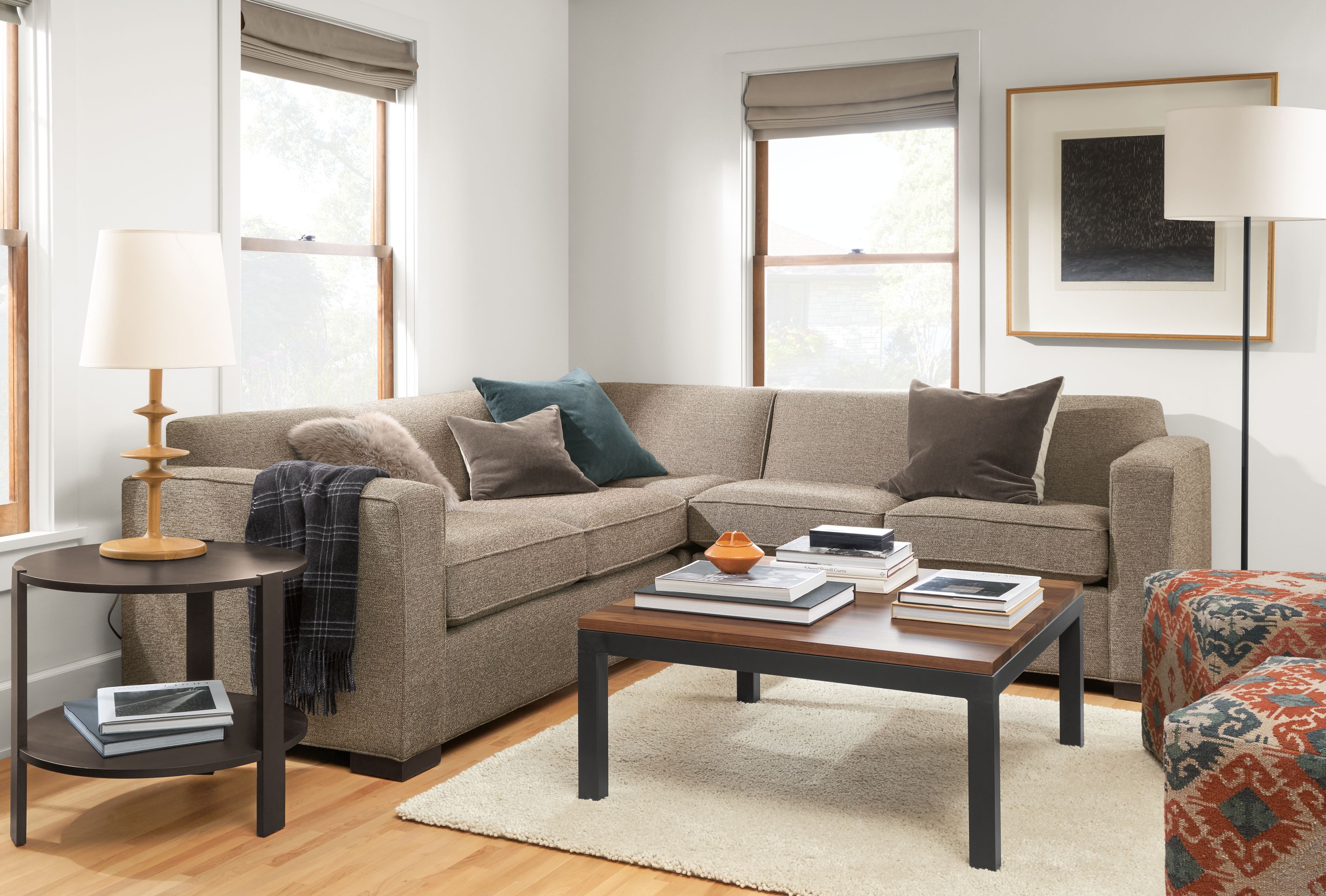 Living room with Ian 3-piece sectional in Tatum Mink fabric next to Indira ottomans in Paprika.