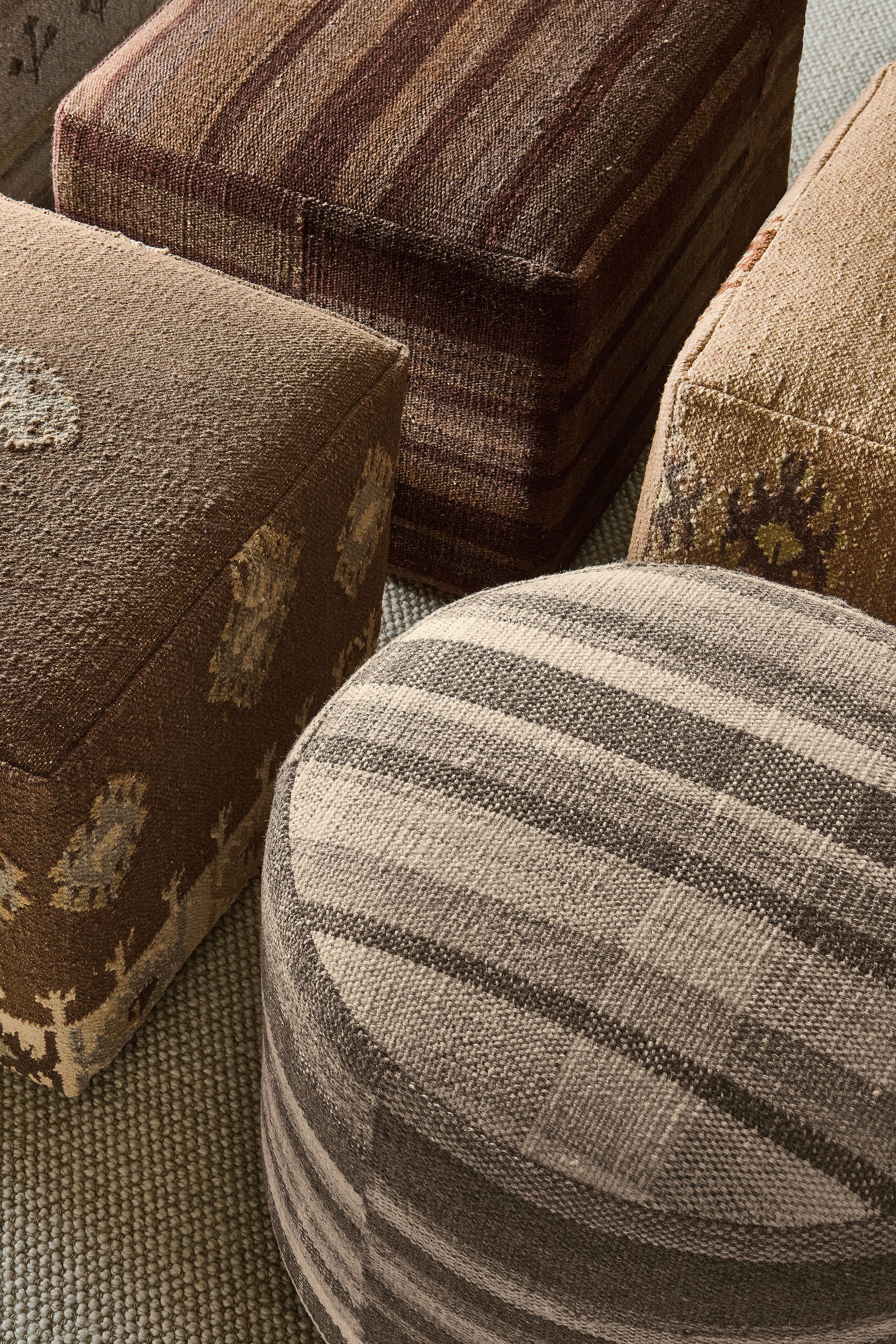 High-angle view of a group of Indira ottomans in Izel Earth, Serra Earth, Misha Grey, Serra Umber and Izel Sienna.