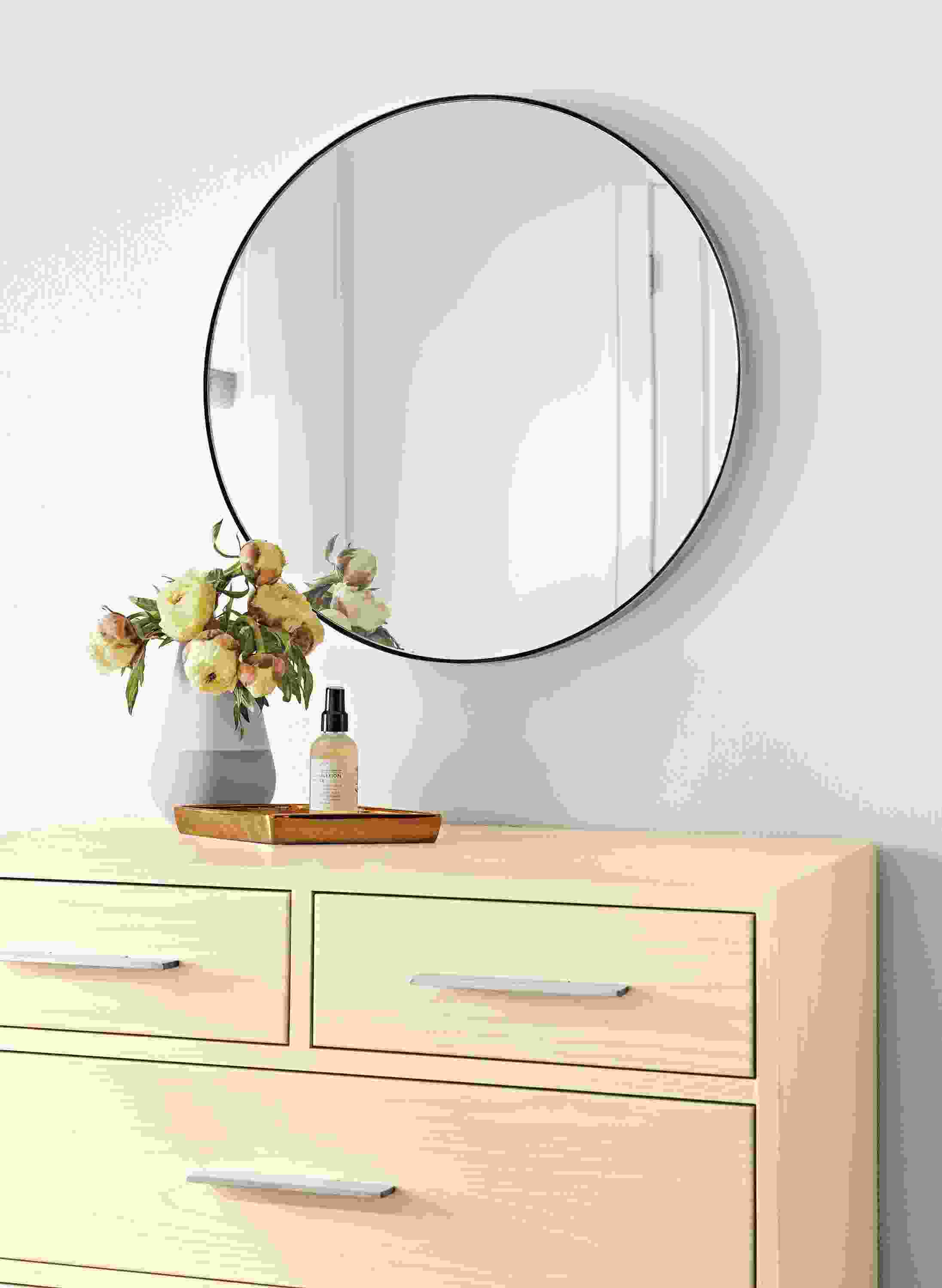 Detail of Infinity custom round mirror in stainless steel above an Alden 4-drawer dresser in sand.