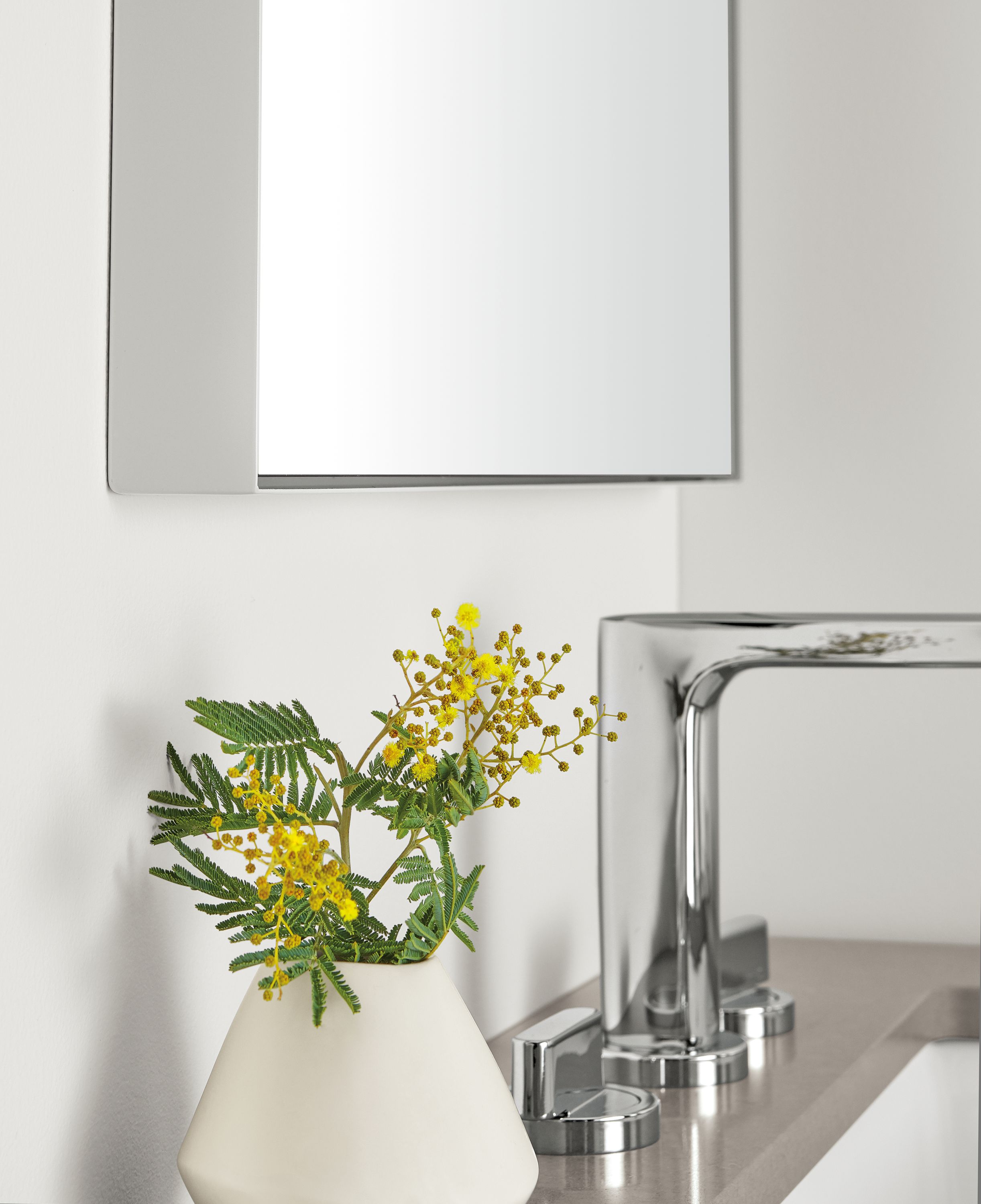 Detail showing the corner and width of an Infinity mirror in light grey above a Kenwood vanity.