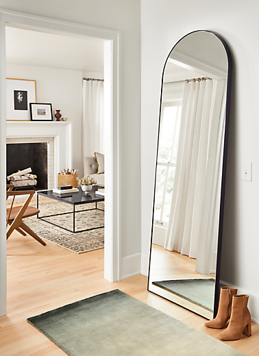 detail of arched infinity floor mirror in onyx gloss in entryway
