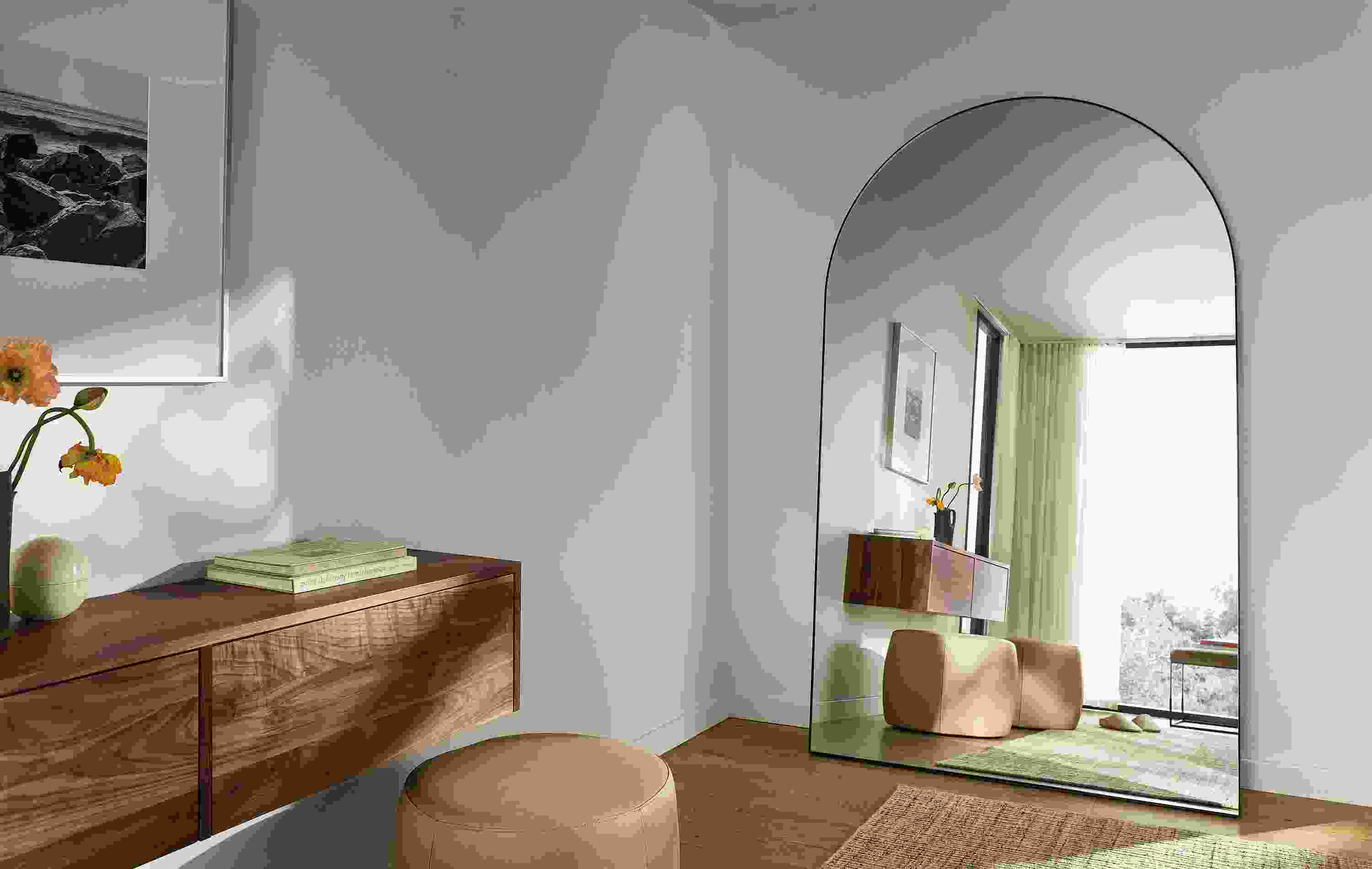 Room corner with detail of Infinity 48 by 80 arched floor mirror in natural steel and Hover wall-mounted cabinet in walnut.