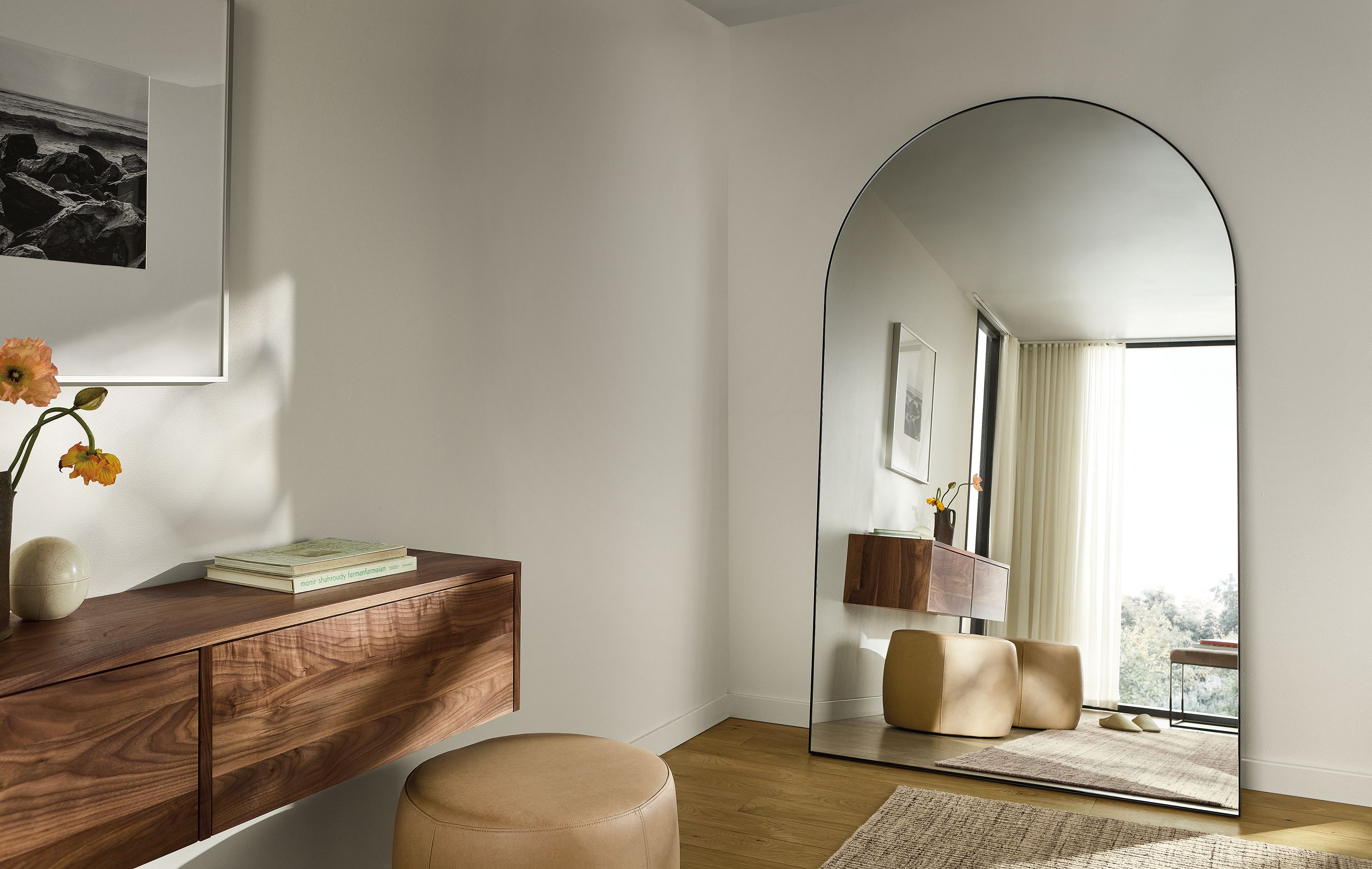 Room corner with detail of Infinity 48 by 80 arched floor mirror in natural steel and Hover wall-mounted cabinet in walnut.