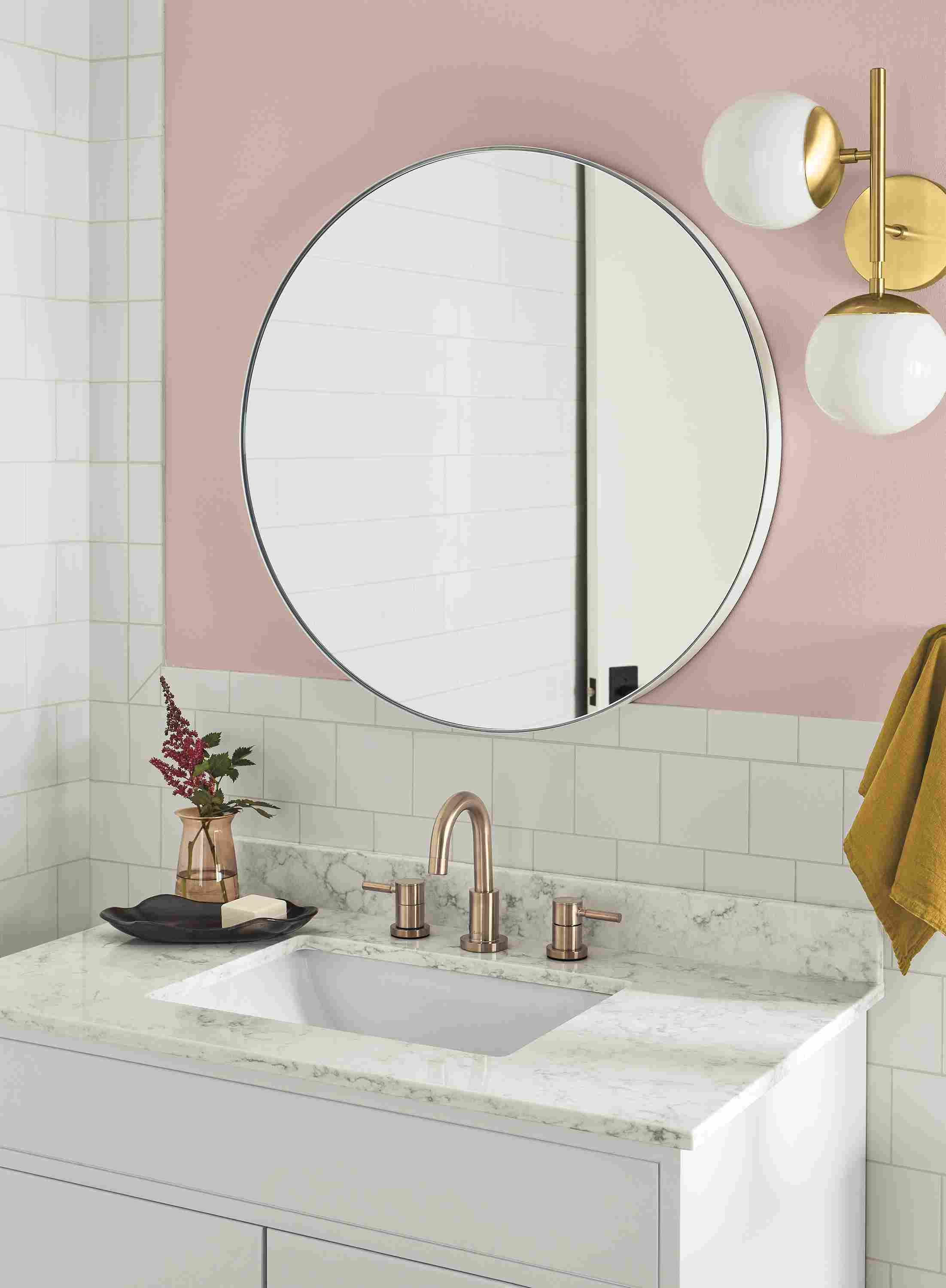 Bathroom with Infinity round wall mirror in white and pearl wall sconce in brass.