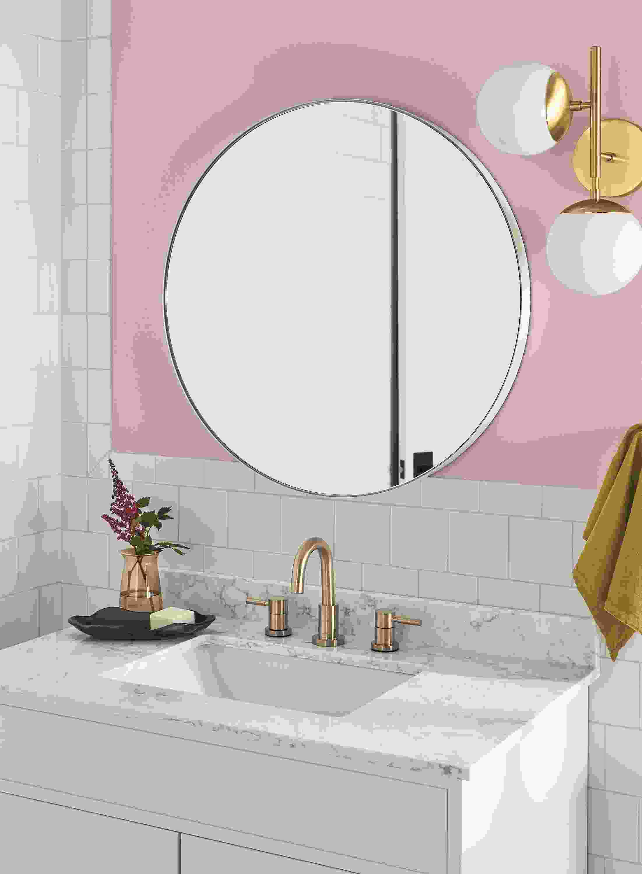 Bathroom with Infinity round wall mirror in white and pearl wall sconce in brass.
