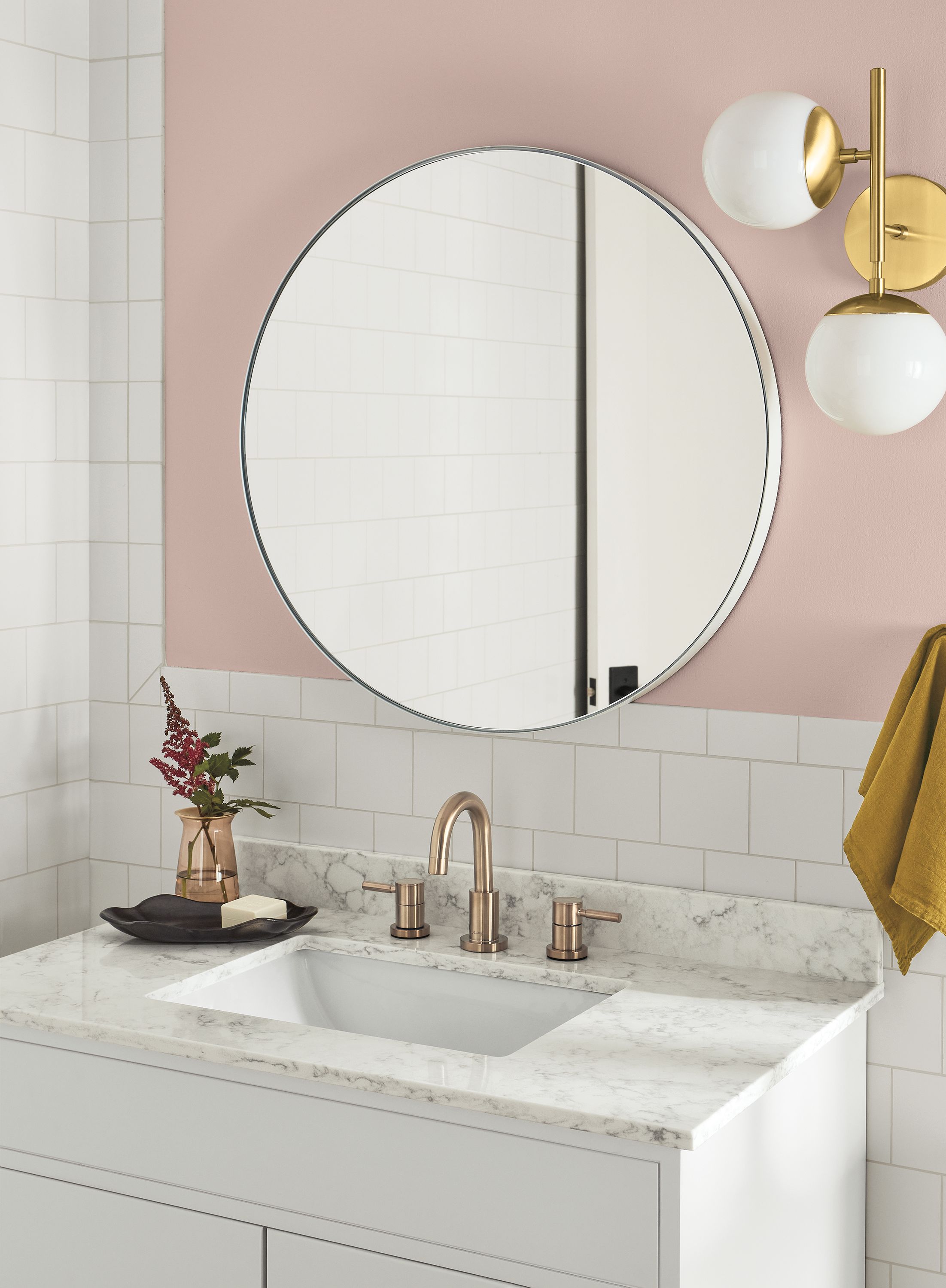 Bathroom with Infinity round wall mirror in white and pearl wall sconce in brass.