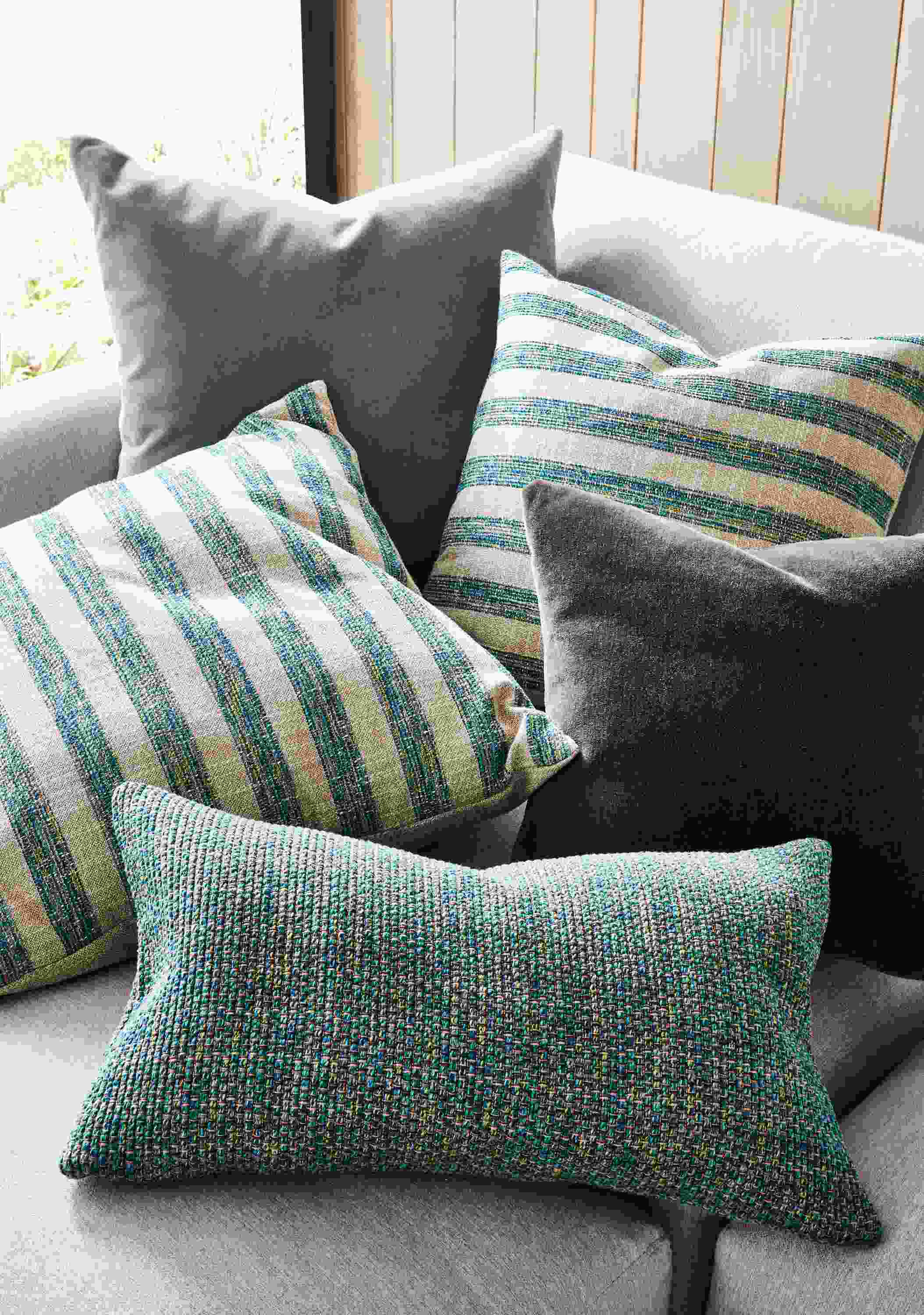 Group of pillows including Interlude and Arcade in Teal, Mohair in sky and charcoal on a Clemens sofa.