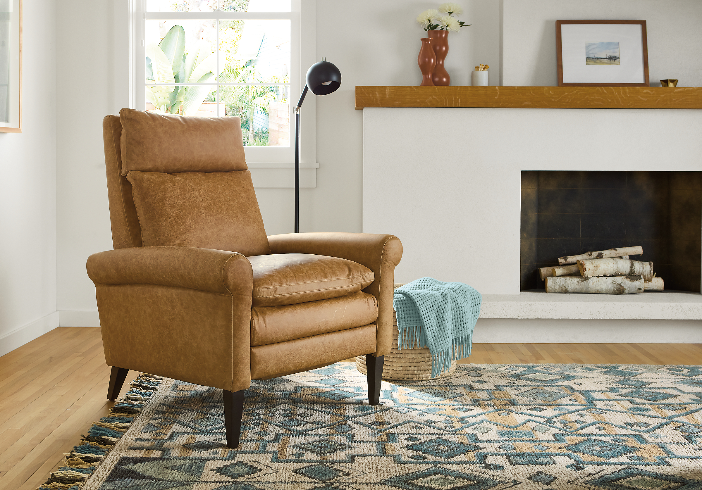 Living room with Isaac recliner in Palermo Camel leather, Ona rug in Ocean and Camber floor lamp in black.