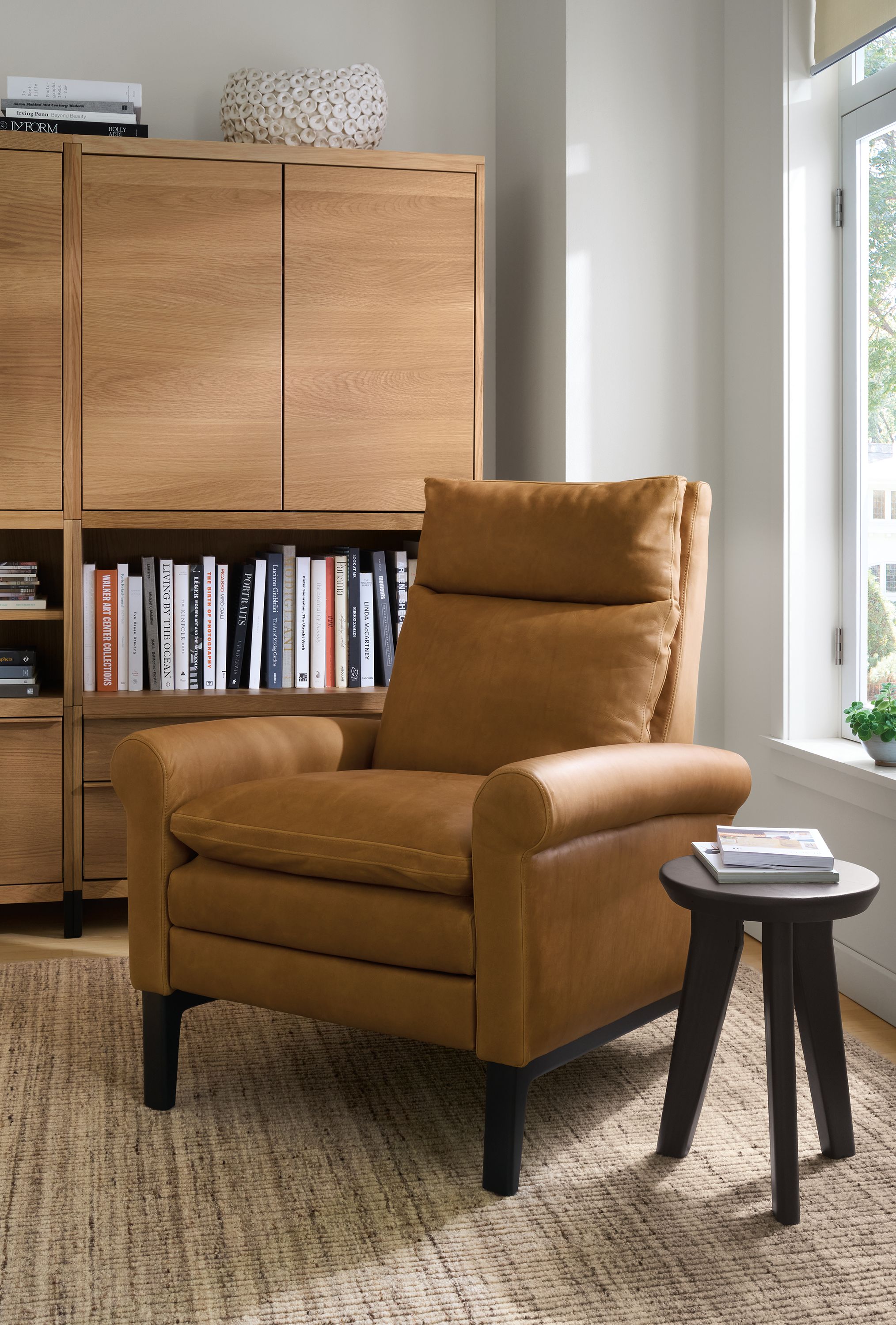 Living room with Isaac recliner in Sarto Camel, Hollins stool in charcoal reclaimed pine and Artis rug in stone.