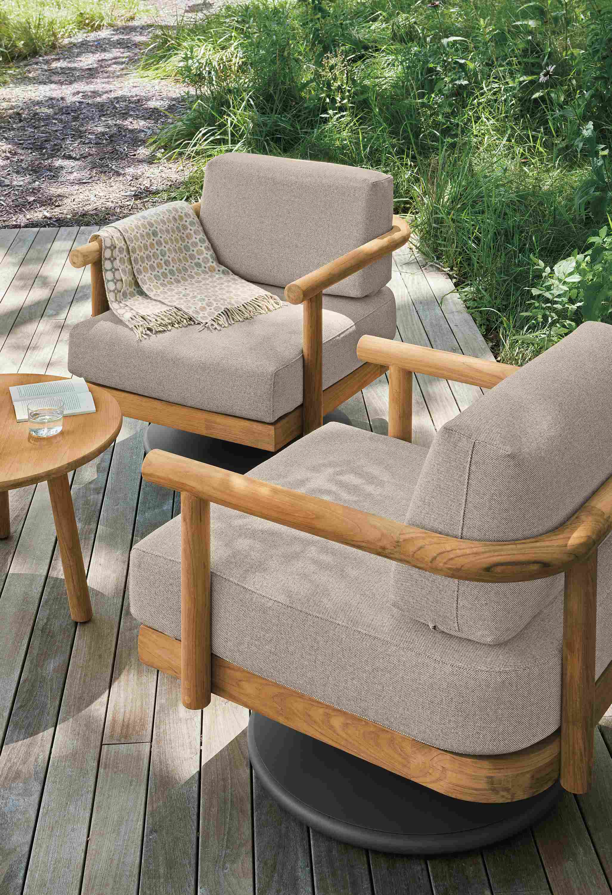 High-angle view of 2 Isley swivel chairs in Mist Oatmeal and Teak Heartwood and  Isley round coffee table in teak heartwood.