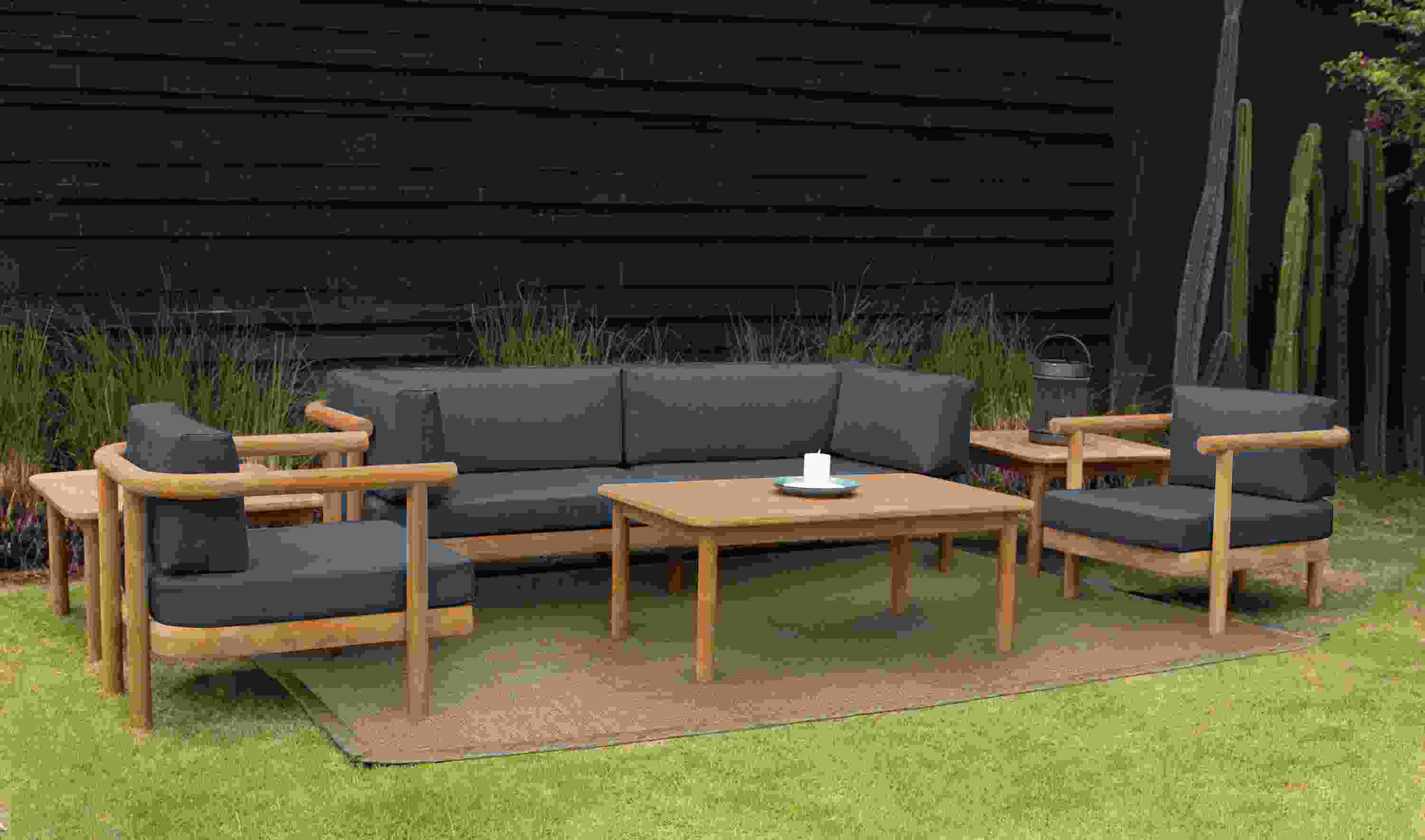 Outdoor setting with Isley 87-inch sofa and two lounge chairs in Bolton navy fabric and Isley coffee table and side tables in teak wood.