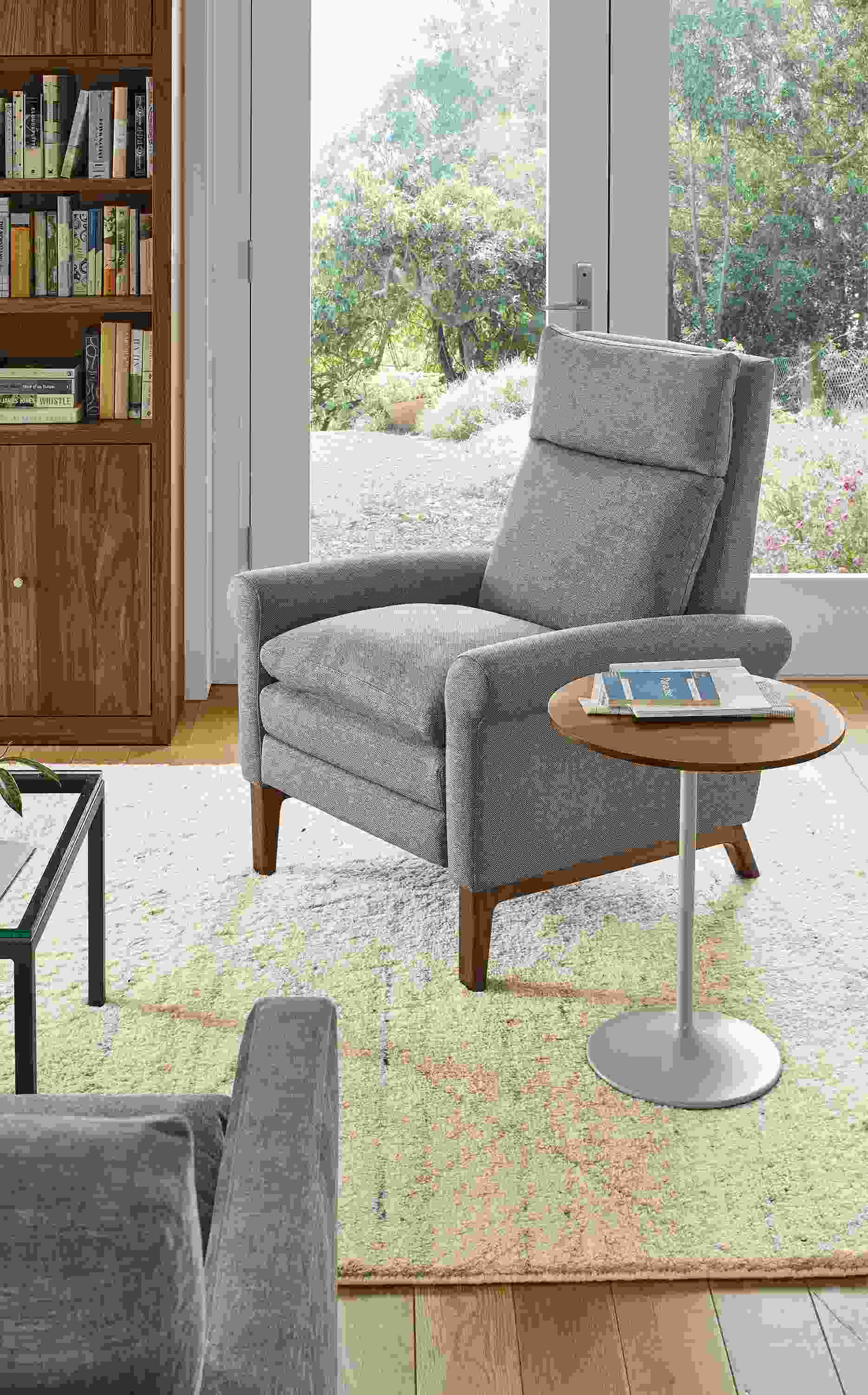 Living area with Isaac Recliner in Sumner graphite fabric and walnut wood base and Kalindi rug in Cement.