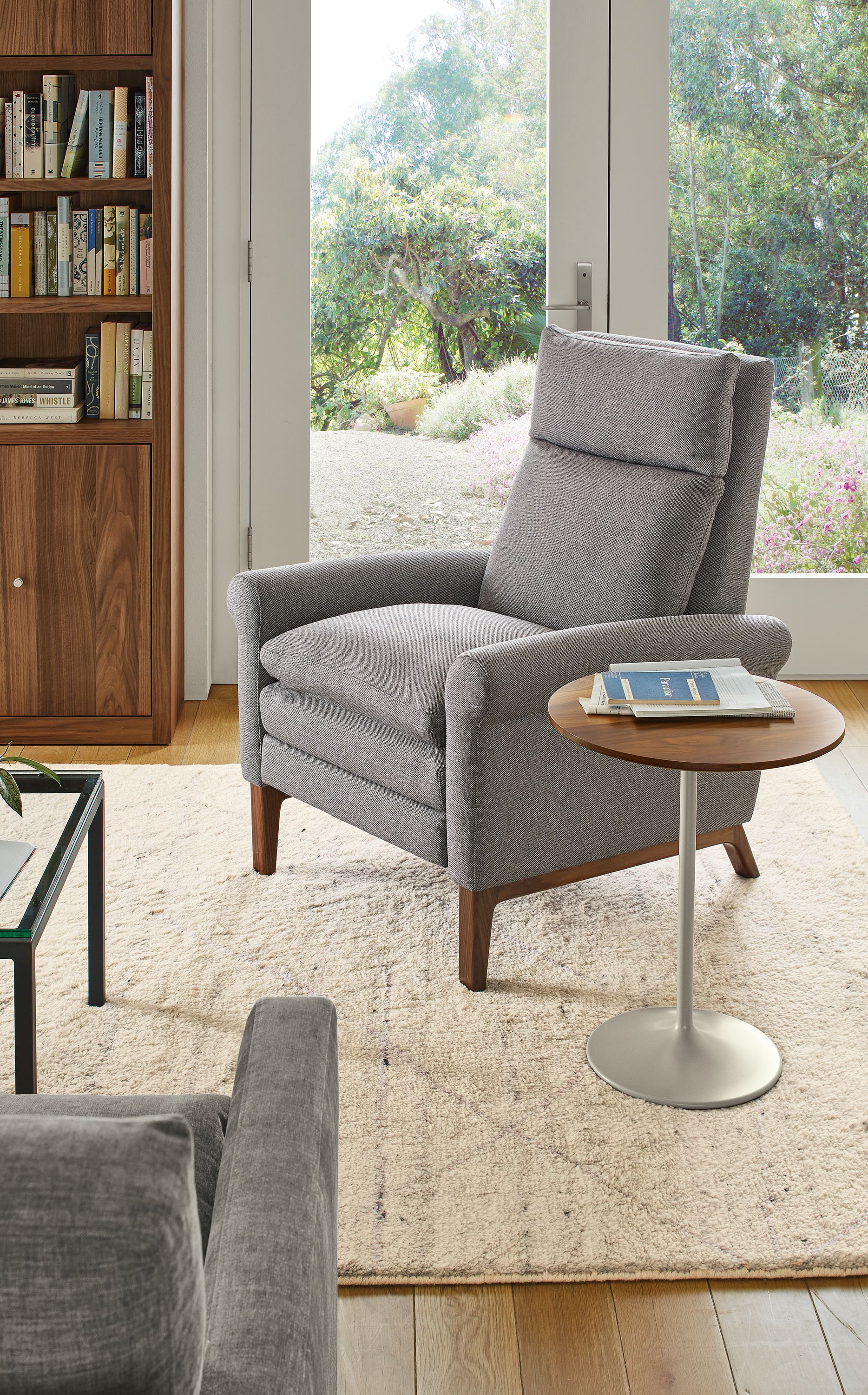 Living area with Isaac Recliner in Sumner graphite fabric and walnut wood base and Kalindi rug in Cement.