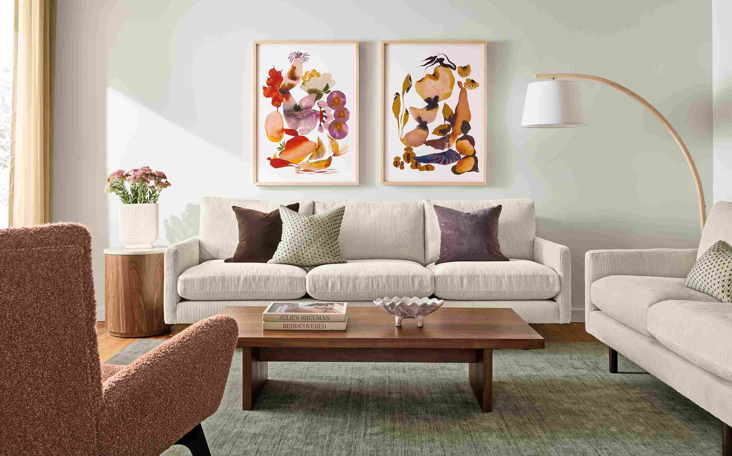 Living room with Jasper sofa and loveseat in Brava Ivory, Corbett coffee table in walnut and Nomad rug in olive.