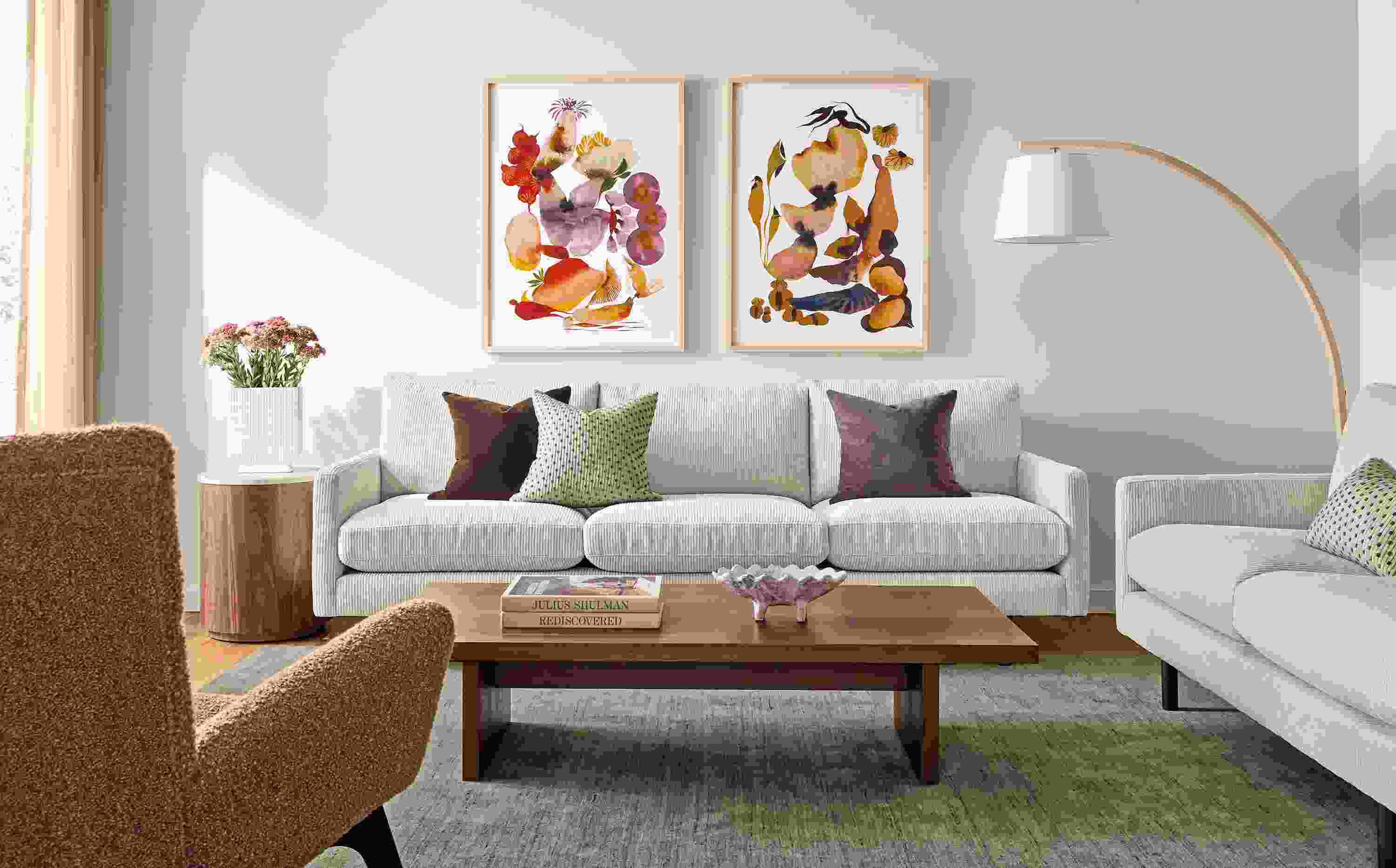 Living room with Jasper sofa and loveseat in Brava Ivory, Corbett coffee table in walnut and Nomad rug in olive.