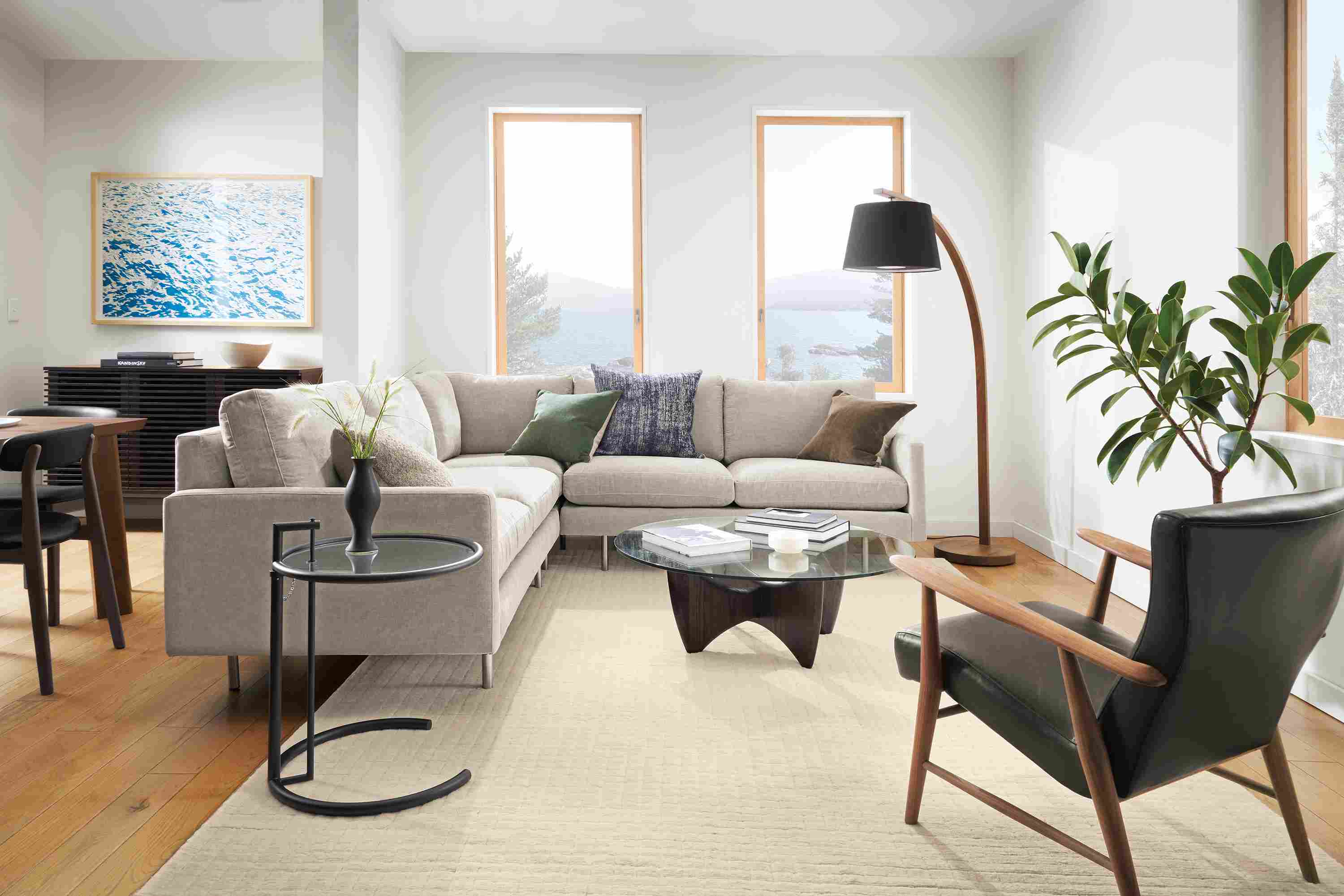 Living room with Jasper sectional in Mori Cement, Jonas chair in Palermo Charcoal leather and walnut, and Sanders coffee table.