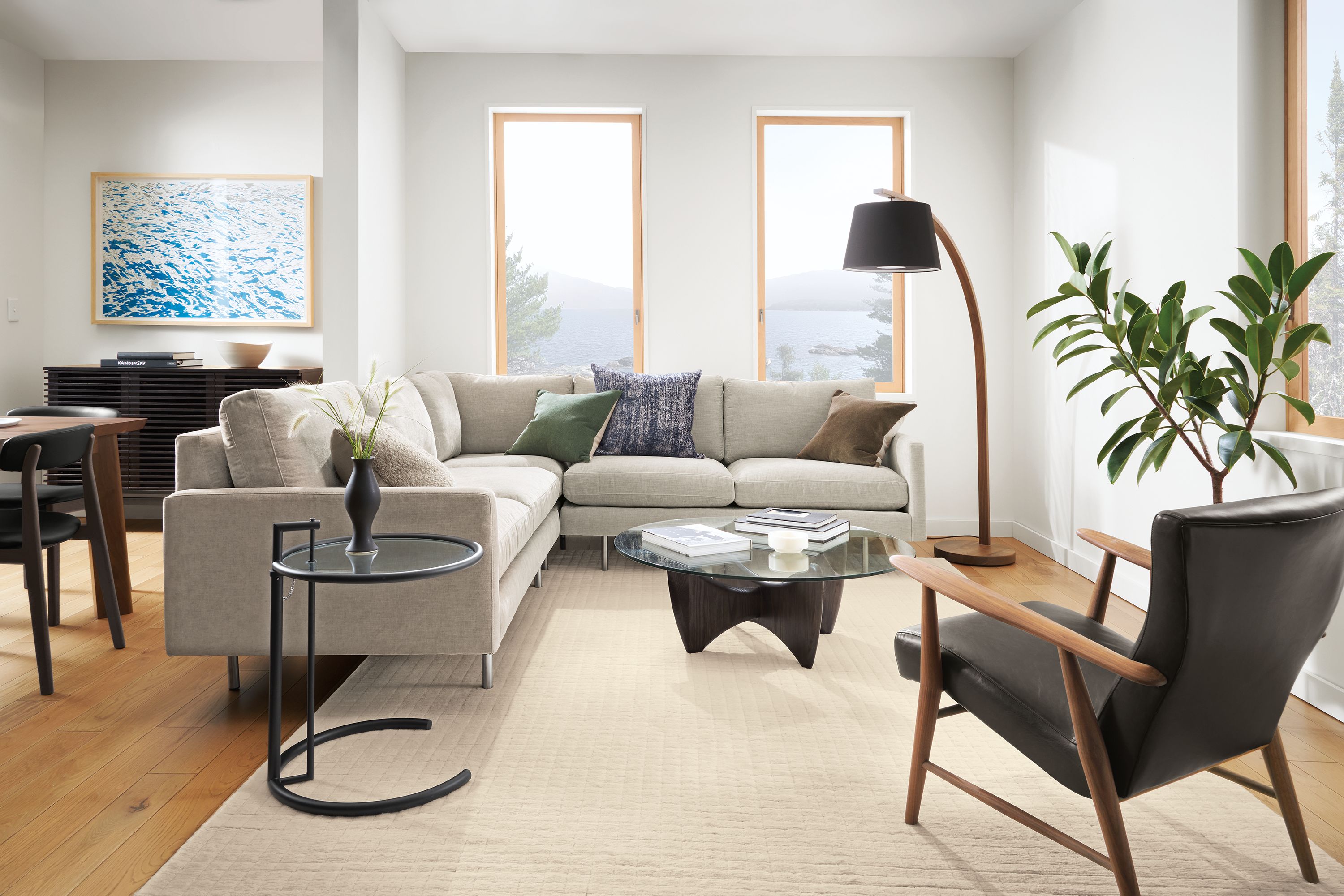 Living room with Jasper sectional in mori cement, jonas chair in charcoal leather and walnut, and sanders coffee table.