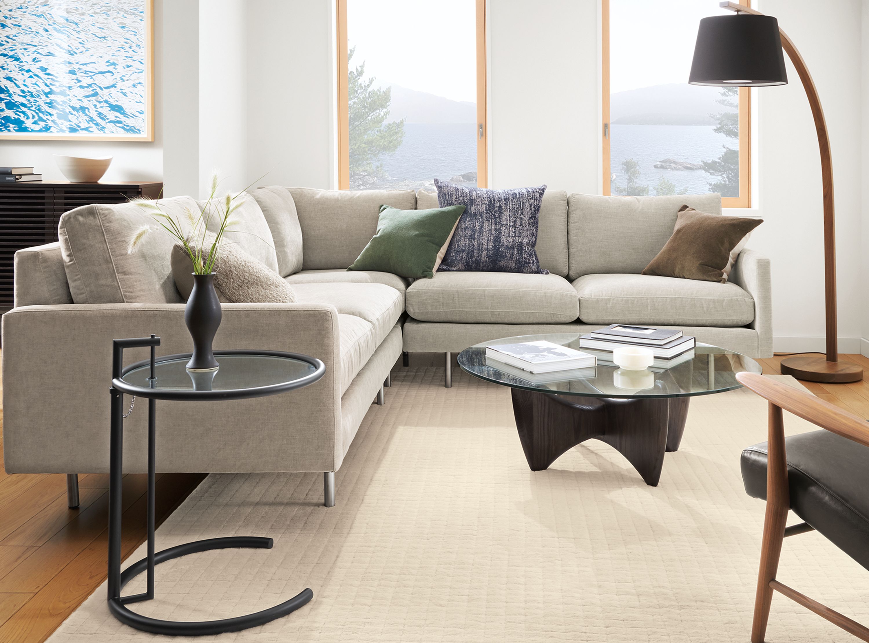 Living room with Jasper sectional in Mori Cement, Jonas chair in Palermo Charcoal leather and walnut, and Sanders coffee table.