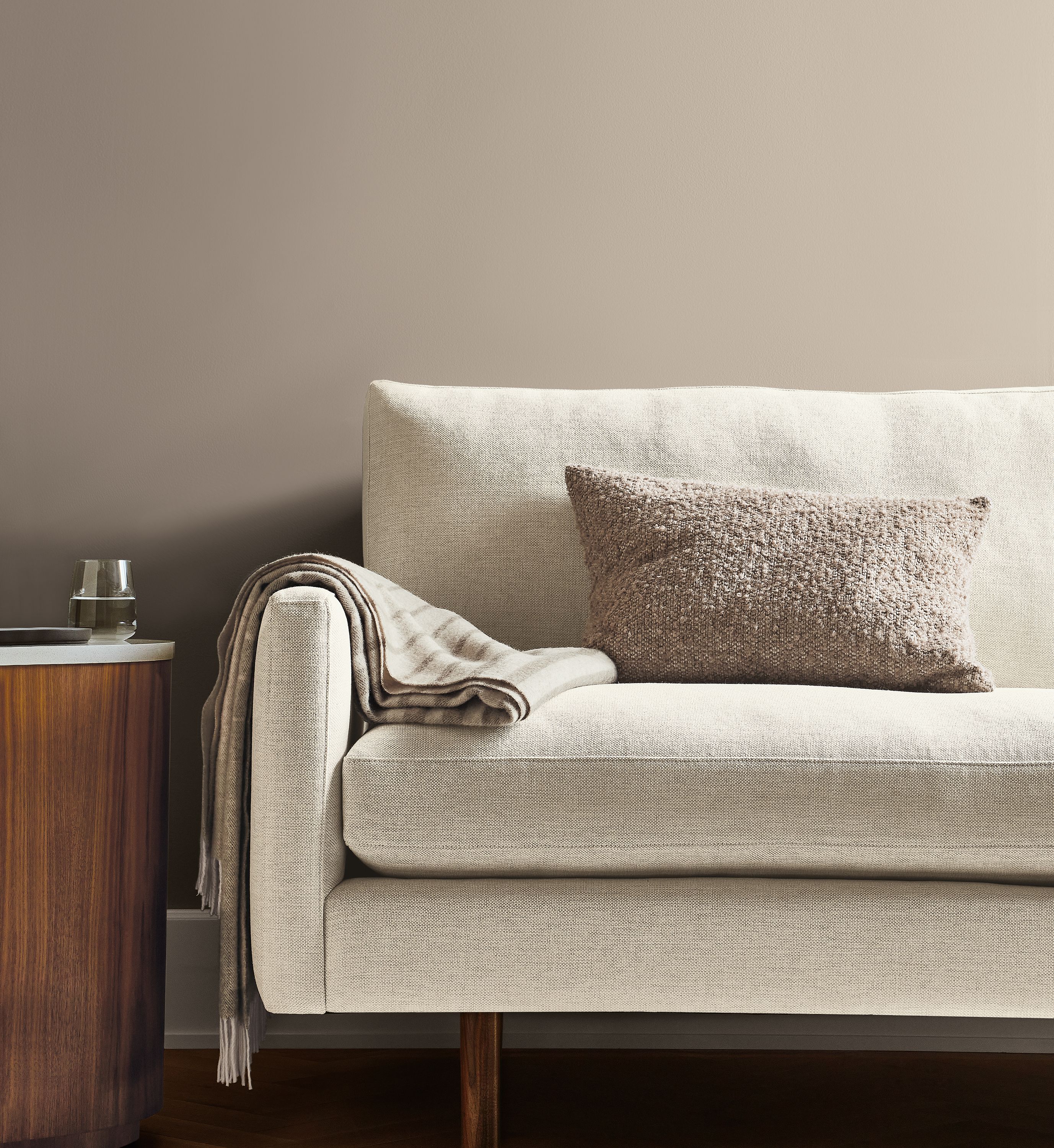 front view of jasper sofa in white fabric with Fairfax throw blanket and palmer pillow.