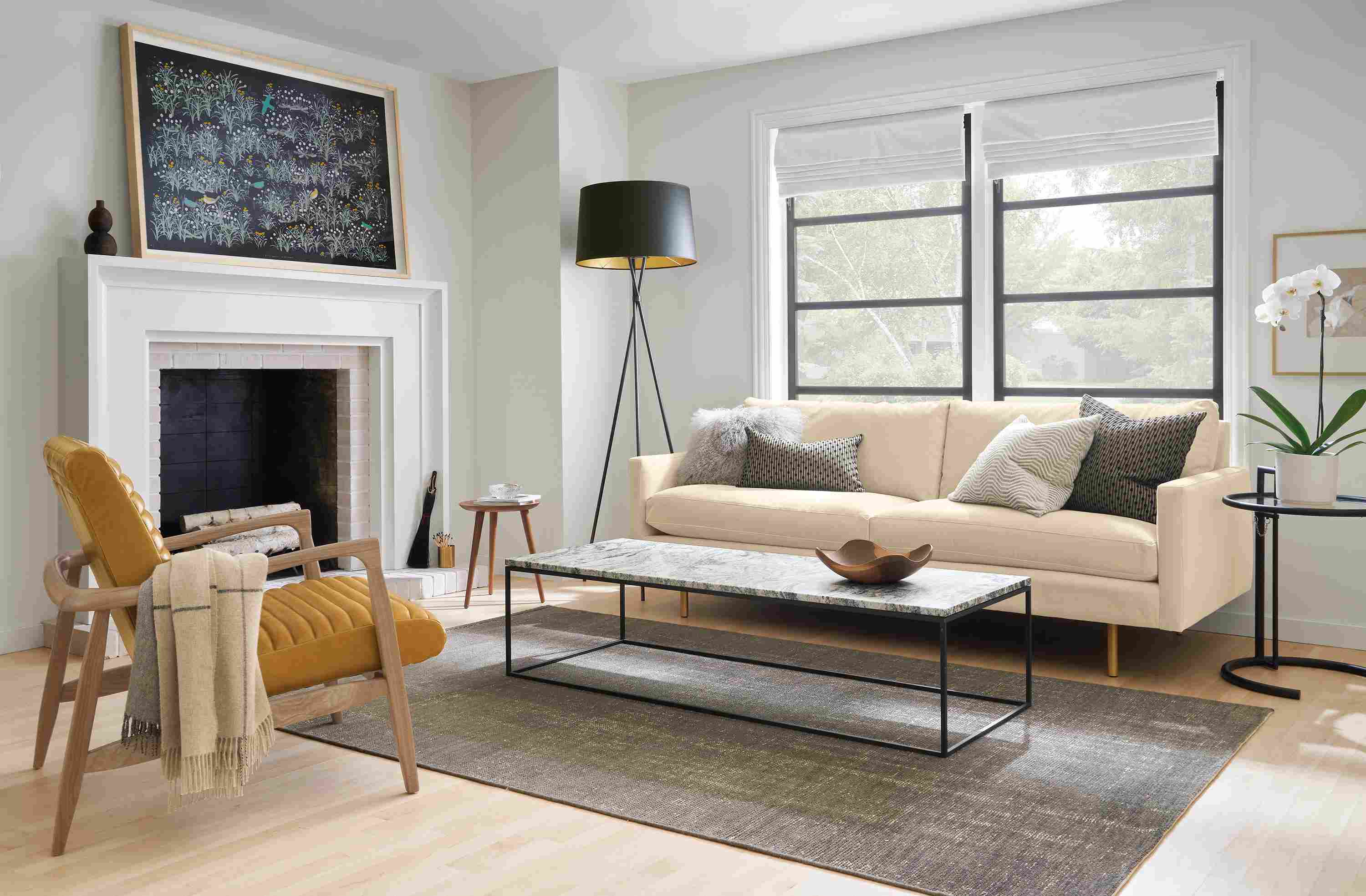 Living room with Jasper sofa in View Wheat with brushed gold legs and Callan chair in Vento Camel leather and rye on red oak.