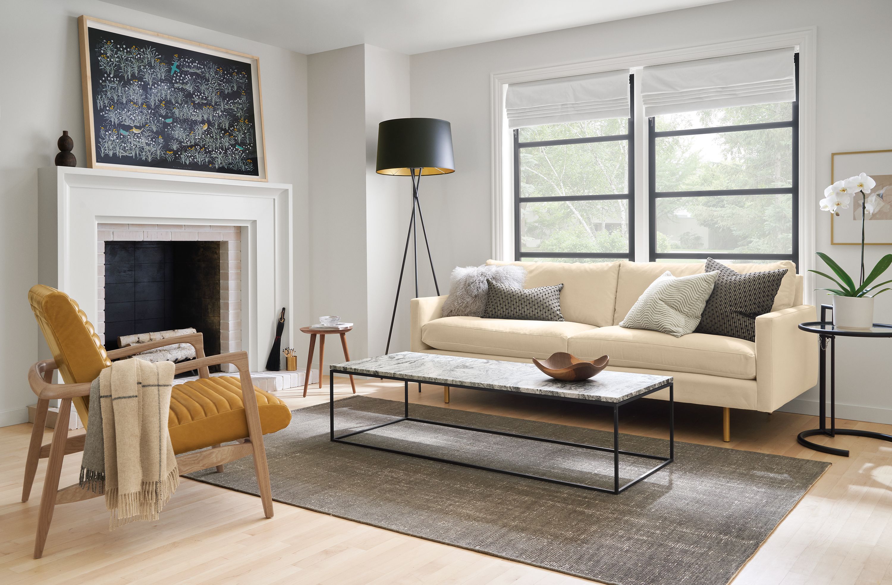 Living room with Jasper sofa in View Wheat with brushed gold legs and Callan chair in Vento Camel leather and rye on red oak.