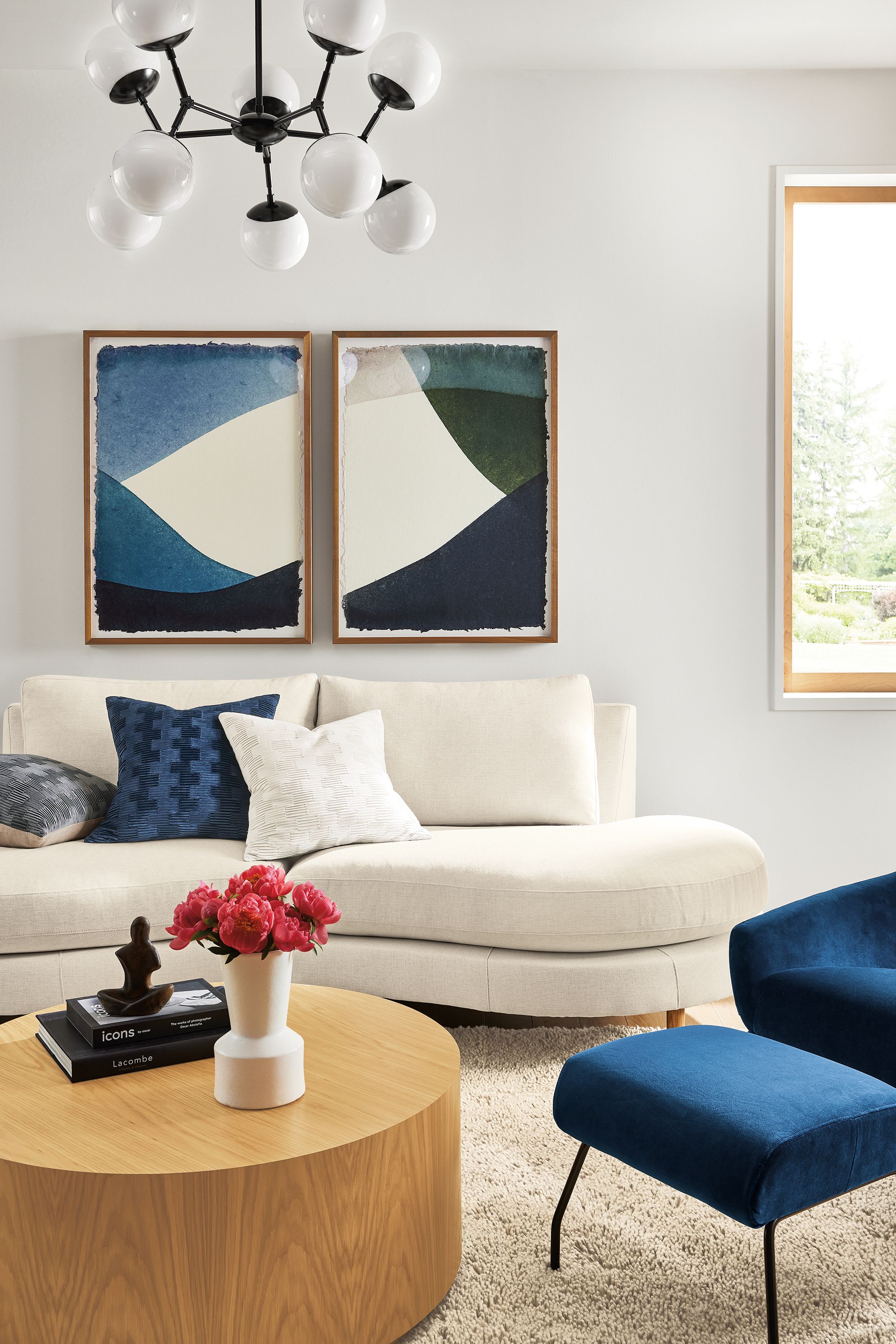 Living room with Jasper curved sofa in Sumner Ivory, Cosma chandelier, Liam coffee table.