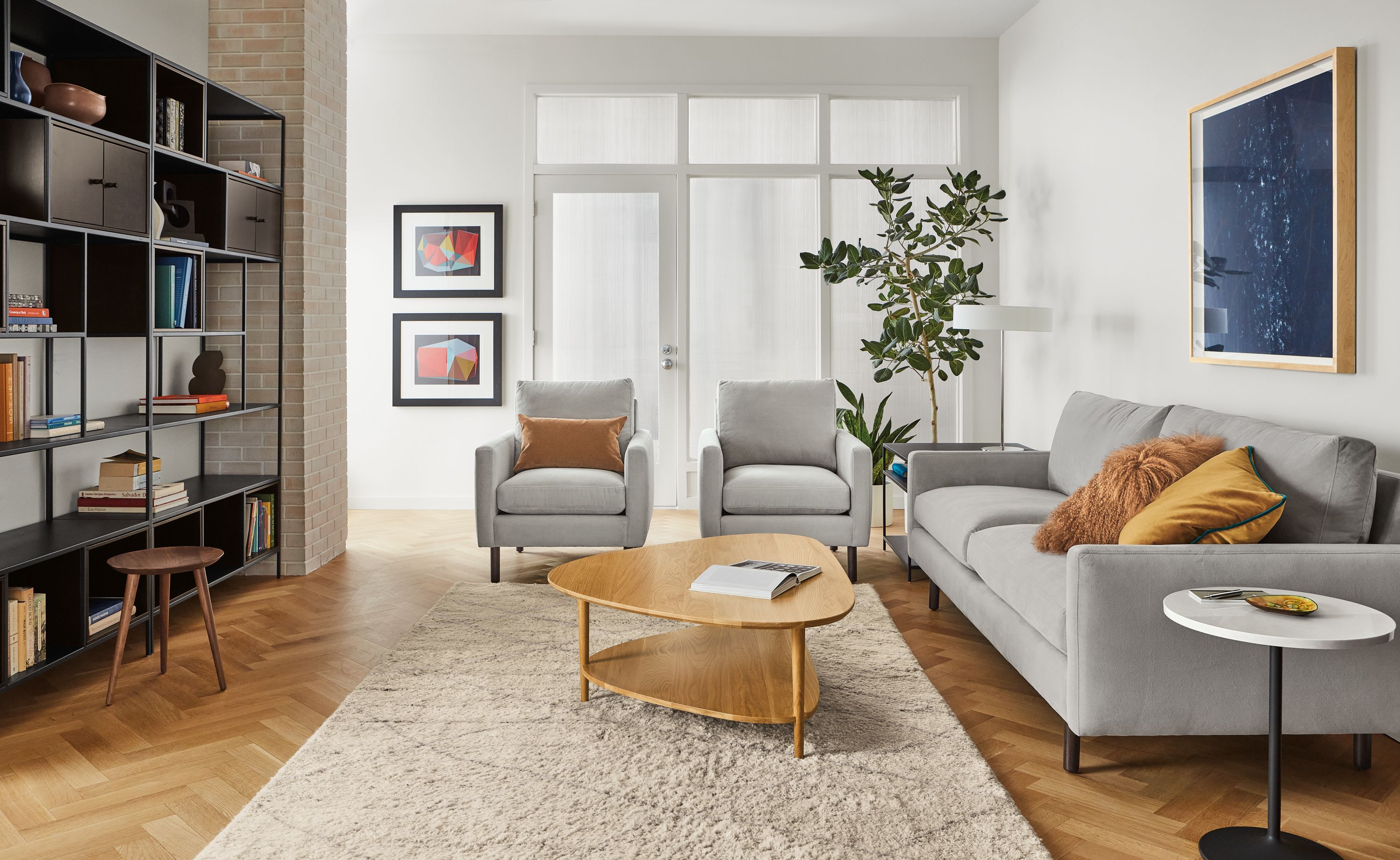 Living room setting with Jasper sofa and two chairs in view grey fabric, Gibson coffee table in white oak and Kalindi rug in cement.