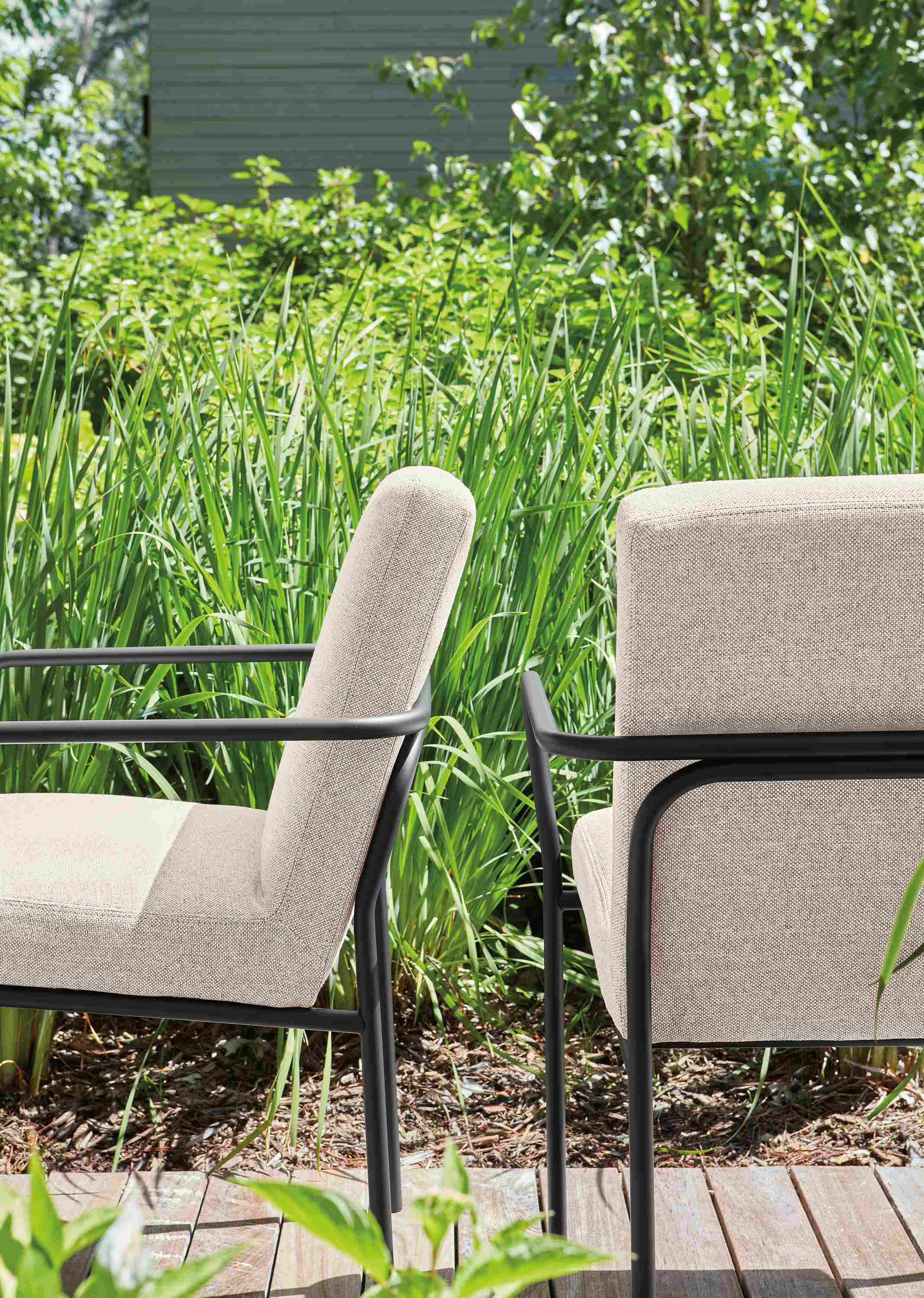 Detail of 2 Joel arm chairs in mist oatmeal and graphite on a deck.