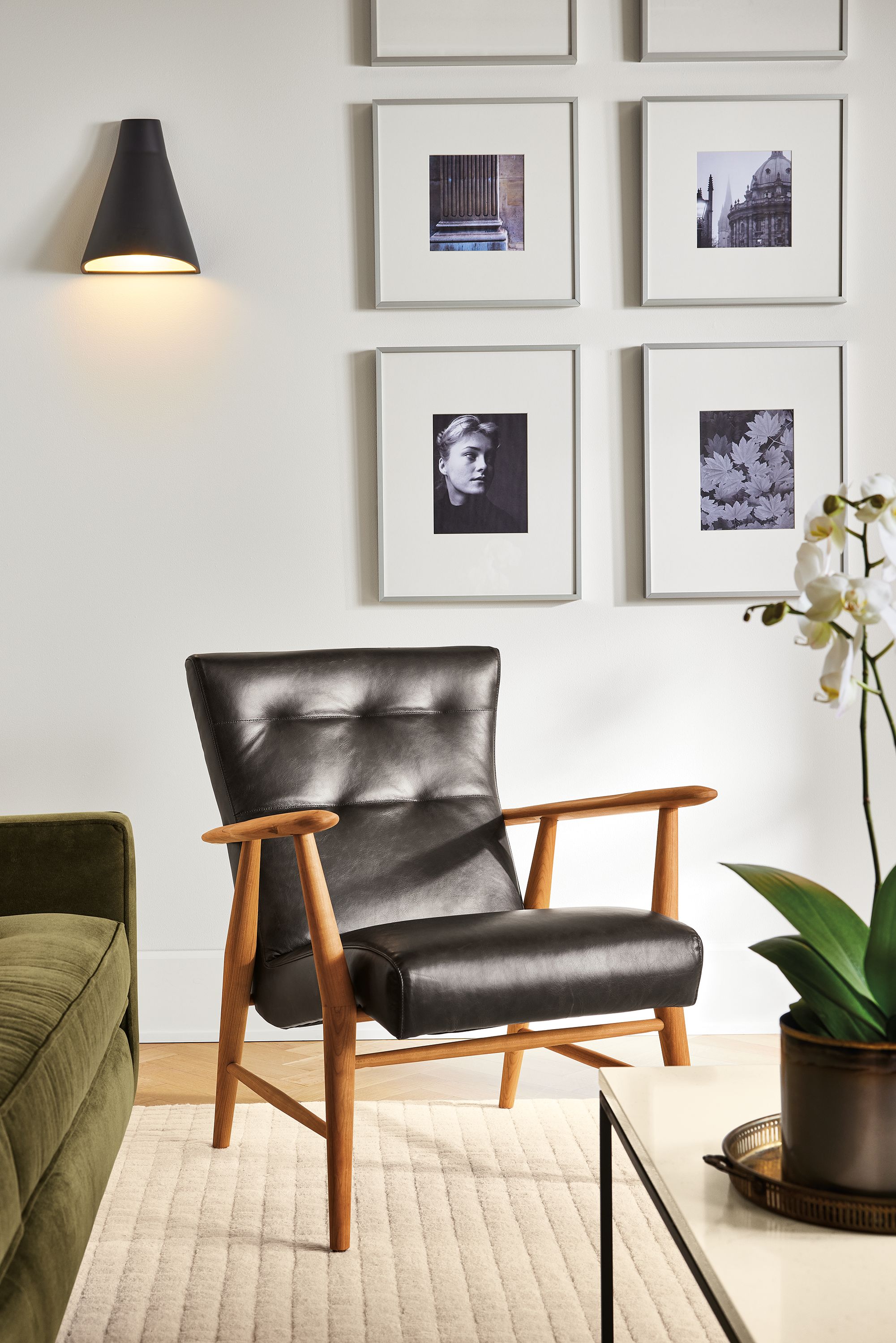 living room with jonas lounge chair in charcoal leather and cherry wood and vassan indoor wall sconce.