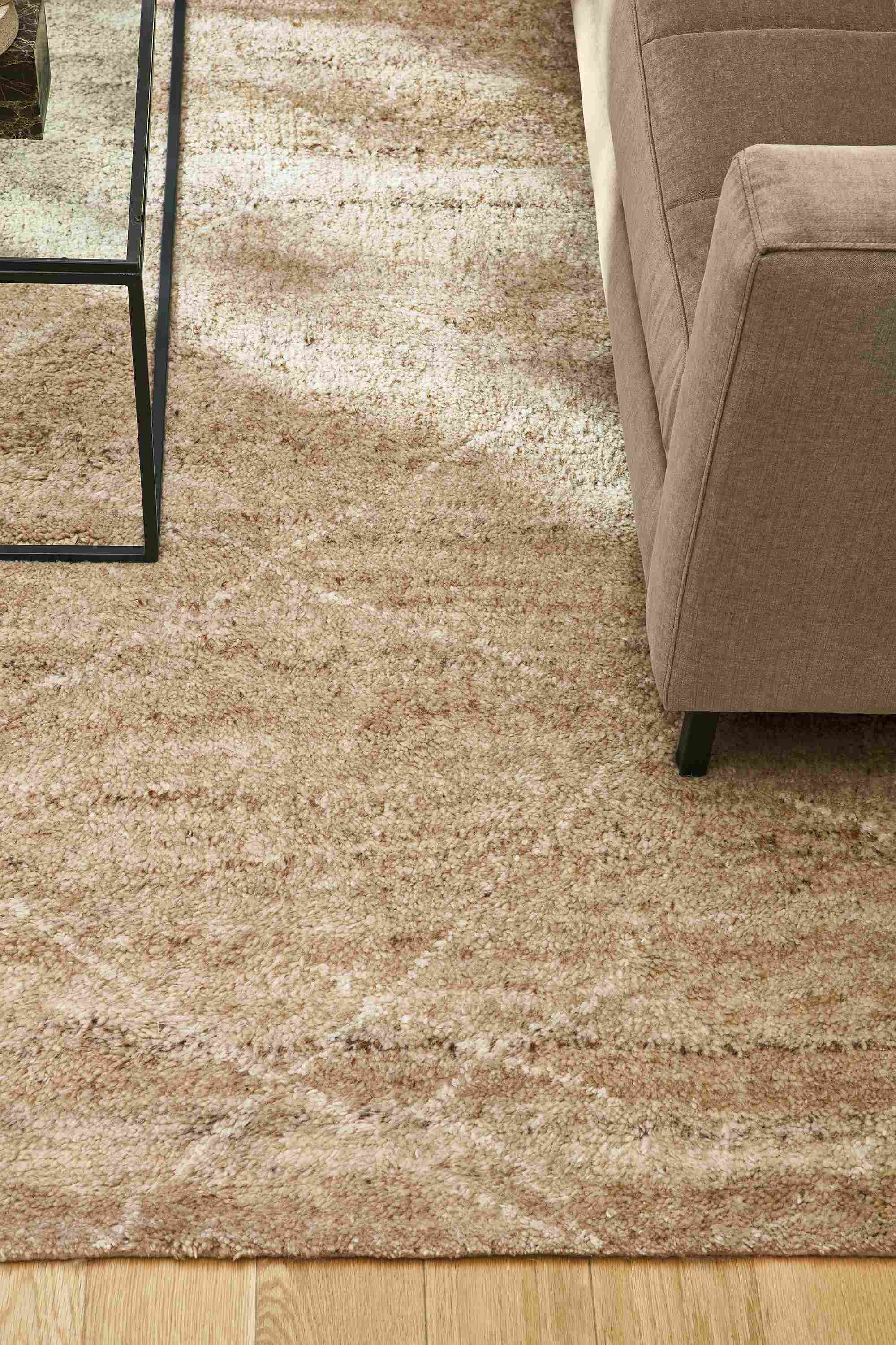 Living room with detail of Kalindi 8 by 10 rug in flax, Lloyd sofa in Windsor Otter and Tyne coffee table with clear glass.