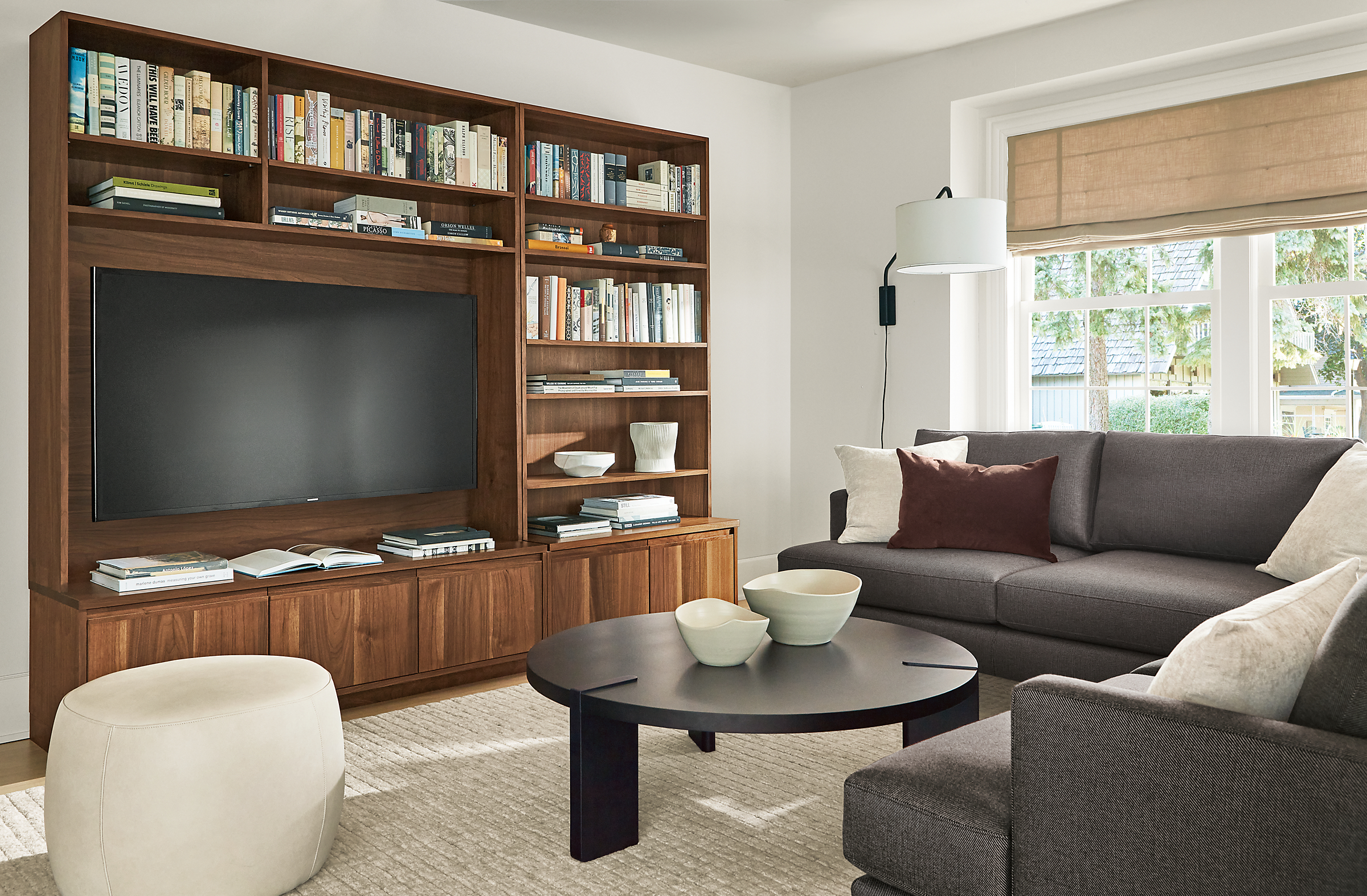 living room with keaton 98-wide media wall unit in walnut, carlton sectional, hanover coffee table and lind ottoman.
